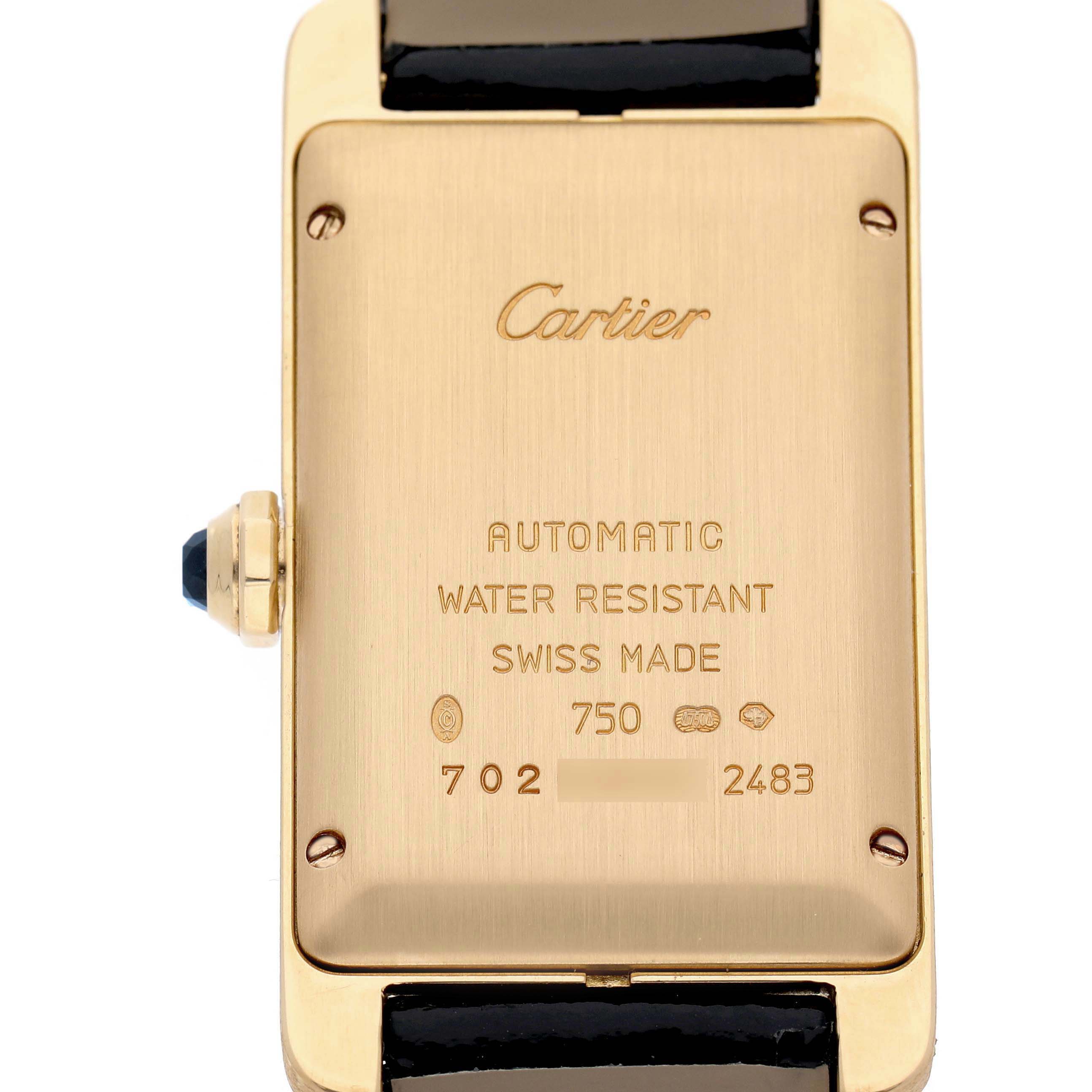The image shows the back of the Cartier Tank Americaine W2603556 Men's Yellow Gold Silver Dial watch, displaying inscriptions and a side view of the crown.