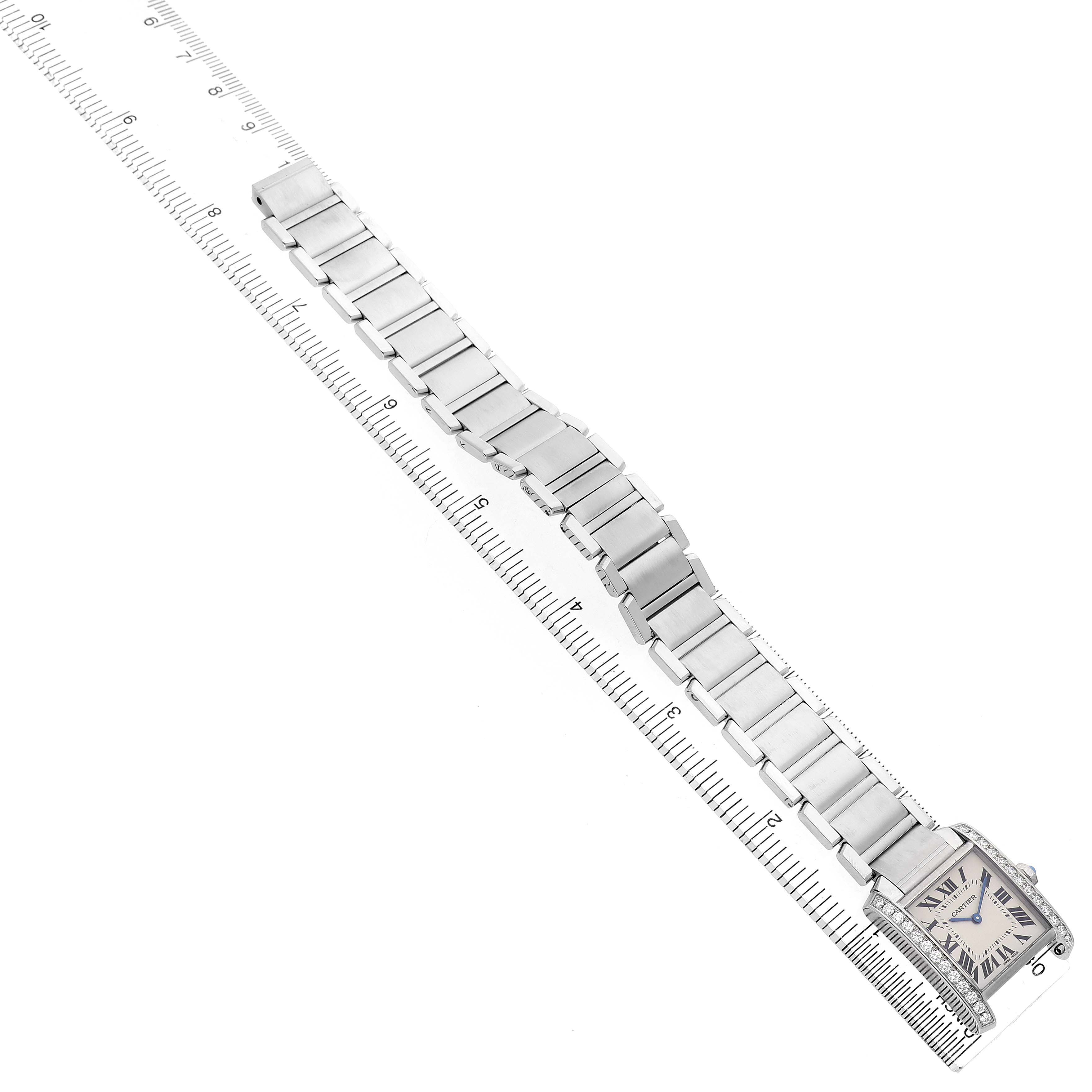 The Cartier Tank Française watch is shown at a top-down angle, highlighting the band, case, and dial along a ruler.