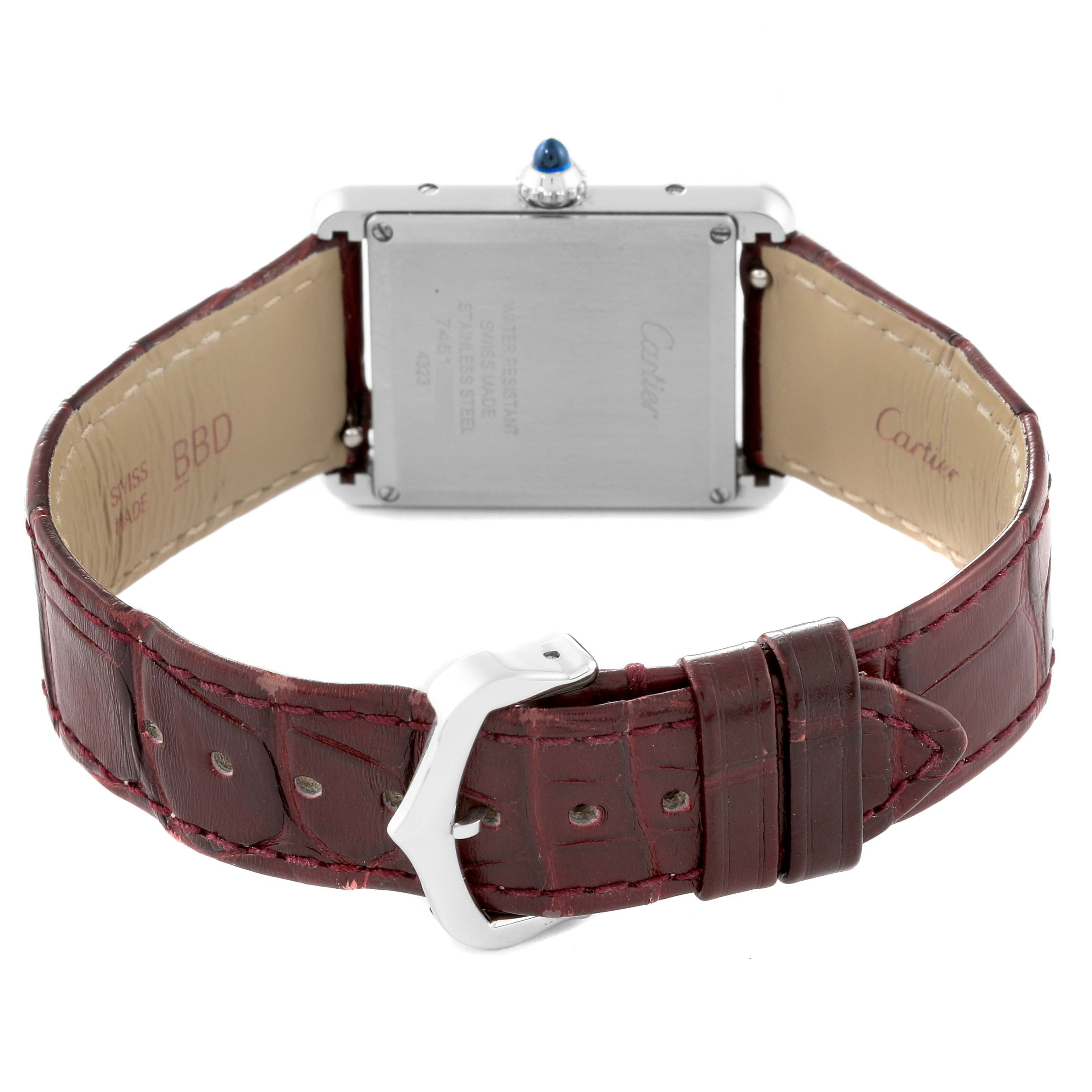 The image shows the back view of the Cartier Tank Must WSTA0054 Women's Stainless Steel Red Dial WSTA0054 Women's Stainless Steel Red Dial watch, featuring its caseback and burgundy leather strap with a buckle.