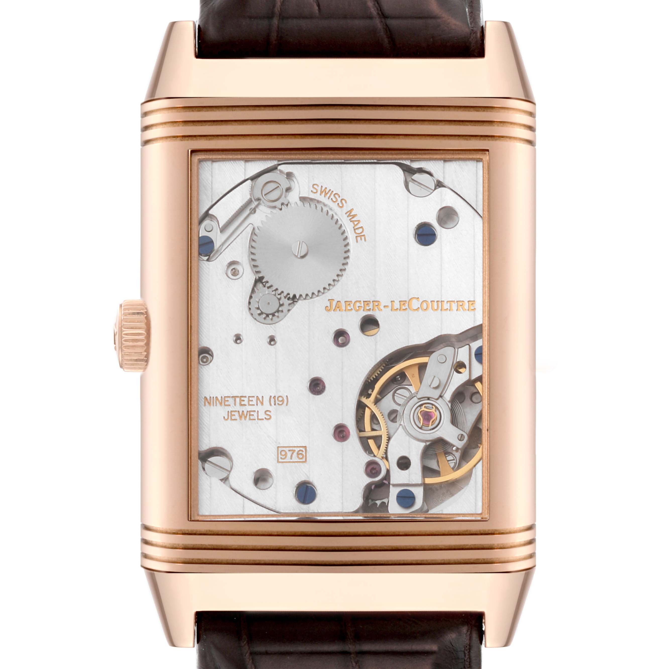 The image shows the back view of a Jaeger-LeCoultre Reverso watch, displaying the movement and internal mechanisms.