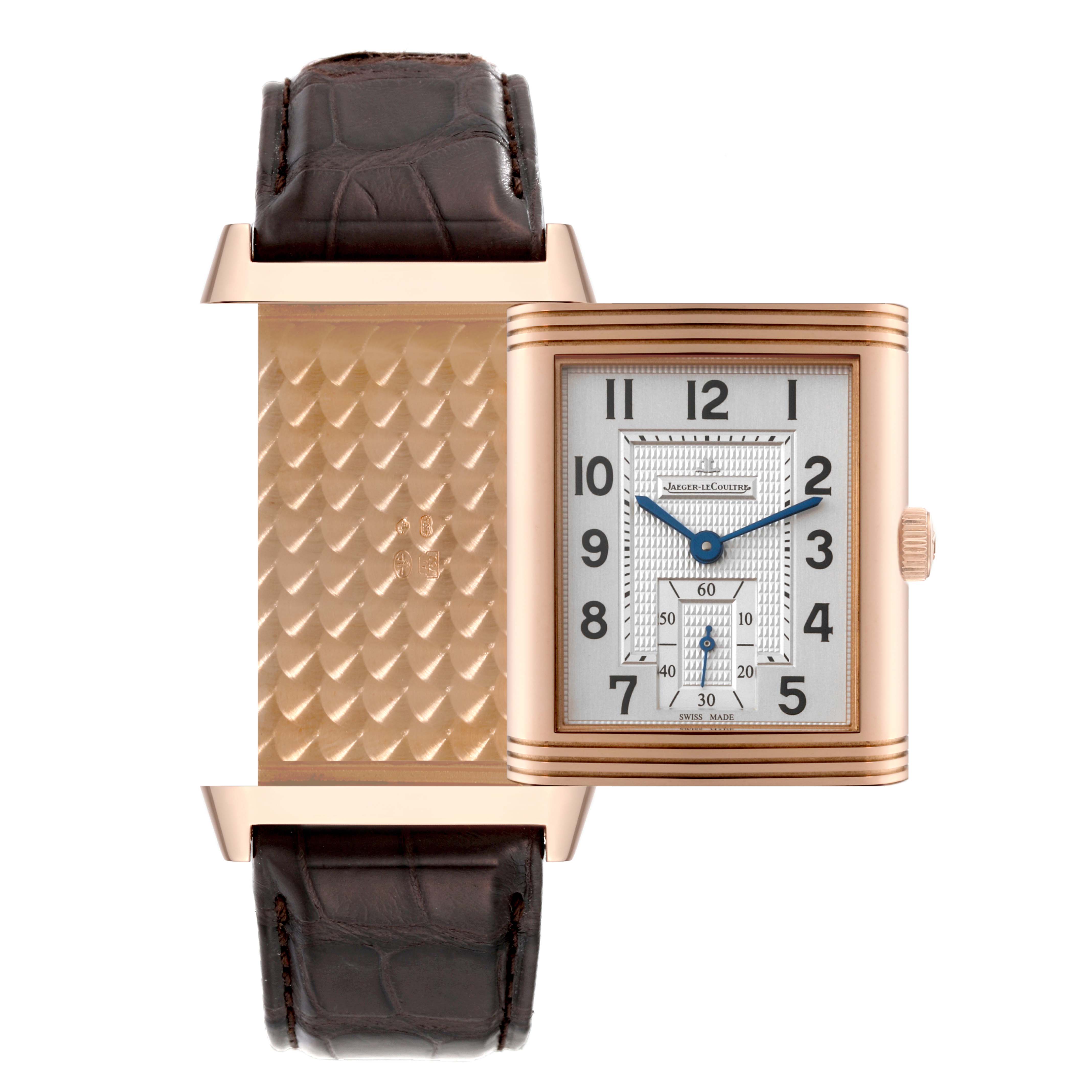 The Jaeger-LeCoultre Reverso watch is shown at an angle revealing both the dial and the intricately patterned reverse side with a leather strap.