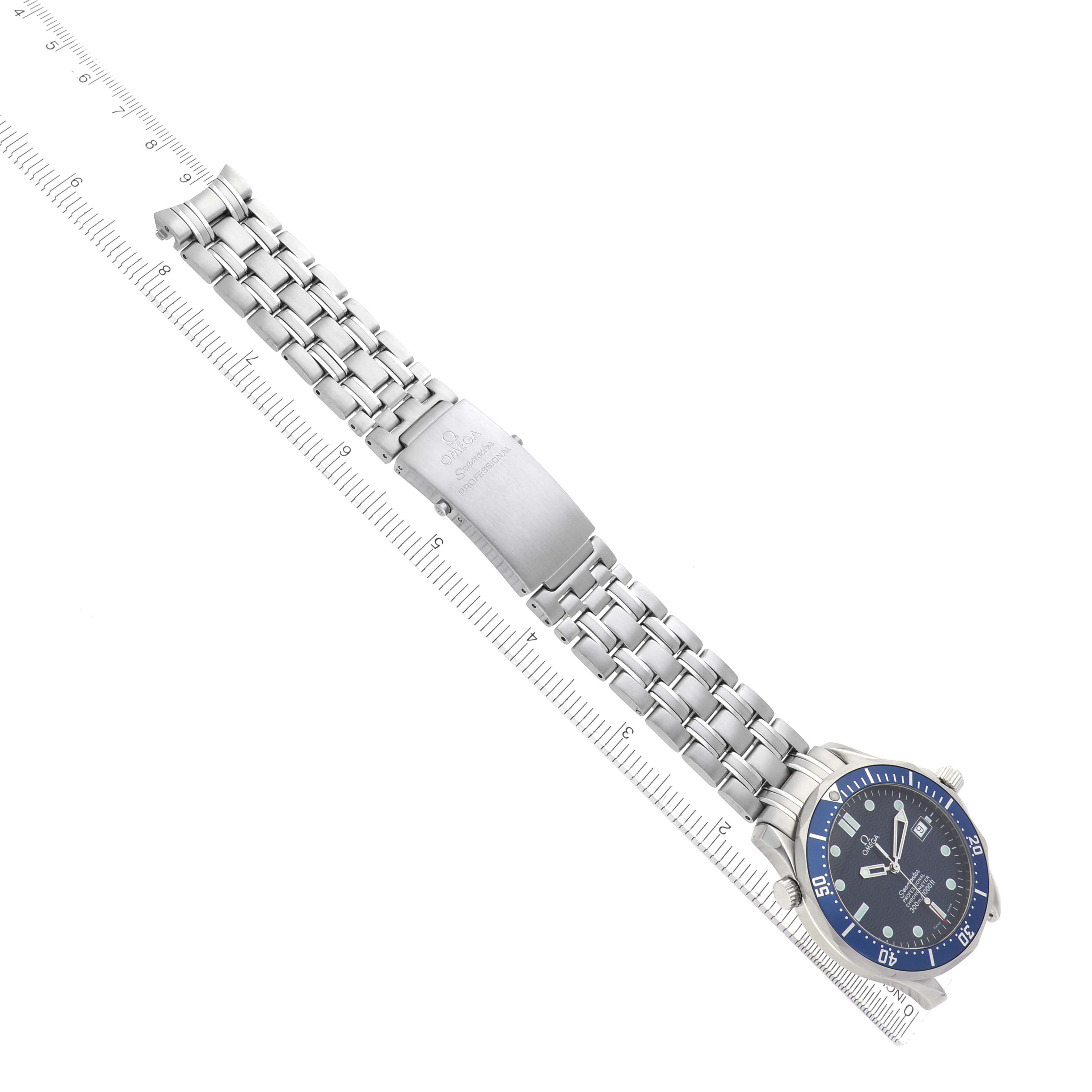 The Omega Seamaster 2531.80.00 Men
s Stainless Steel Blue Dial watch is shown at an angle displaying its face, bezel, metal bracelet, and clasp, alongside a ruler for scale.