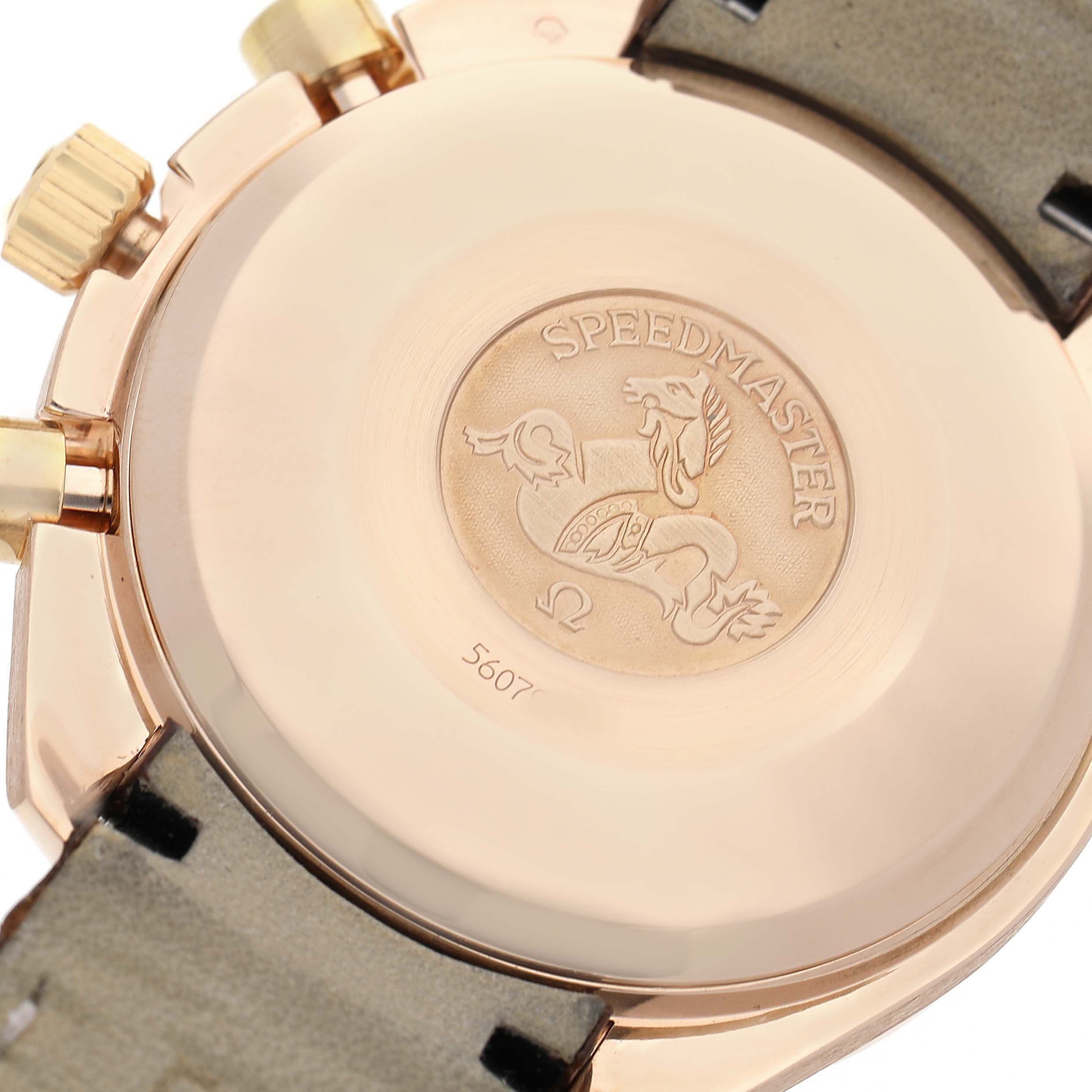 The image shows the backside of an Omega Speedmaster watch, featuring the case back, crown, and pushers.