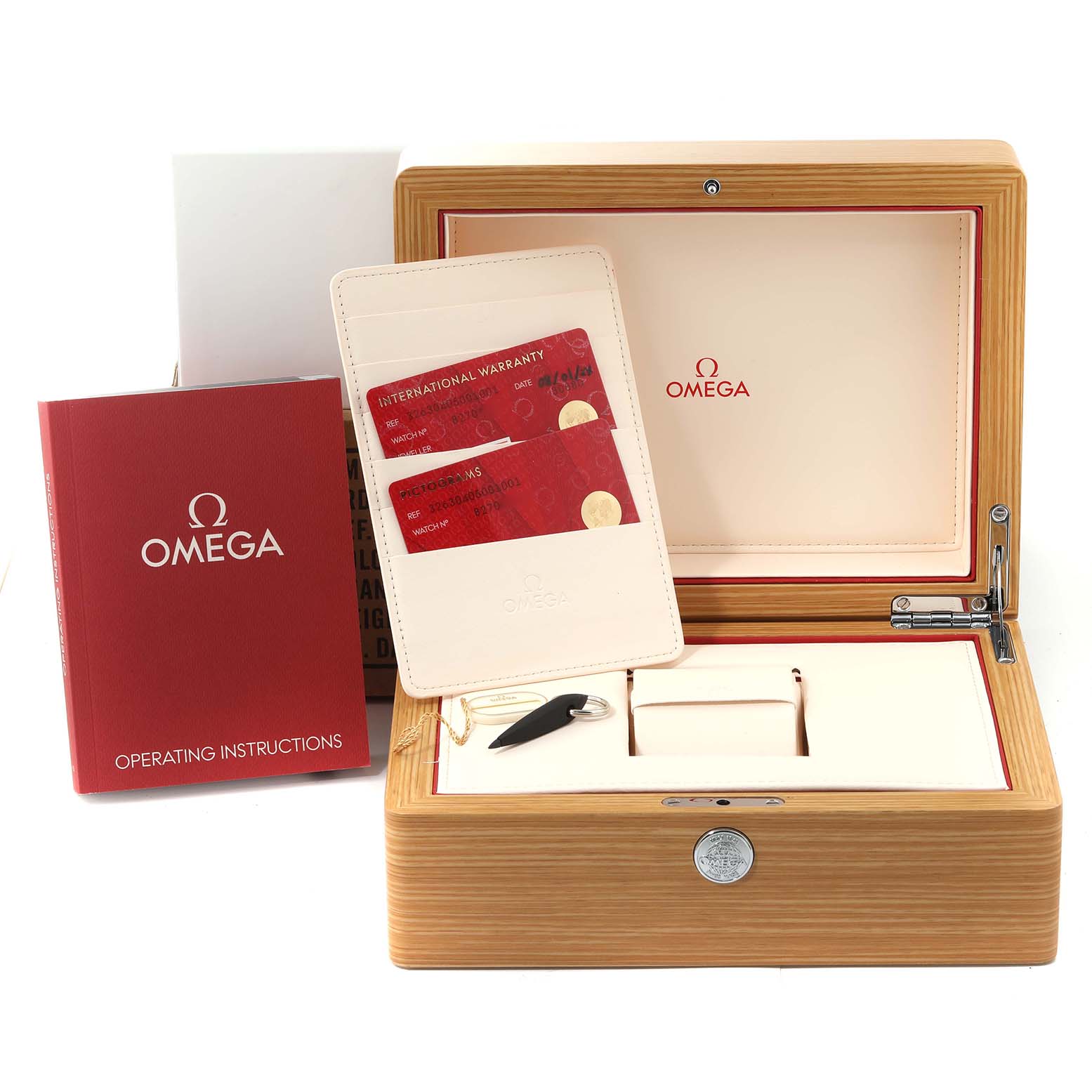 The image shows an open Omega Speedmaster 326.30.40.50.01.001 Men
s Stainless Steel Black Dial 326.30.40.50.01.001 Men
s Stainless Steel Black Dial watch box with warranty cards, operating instructions, and a tool arranged around it.