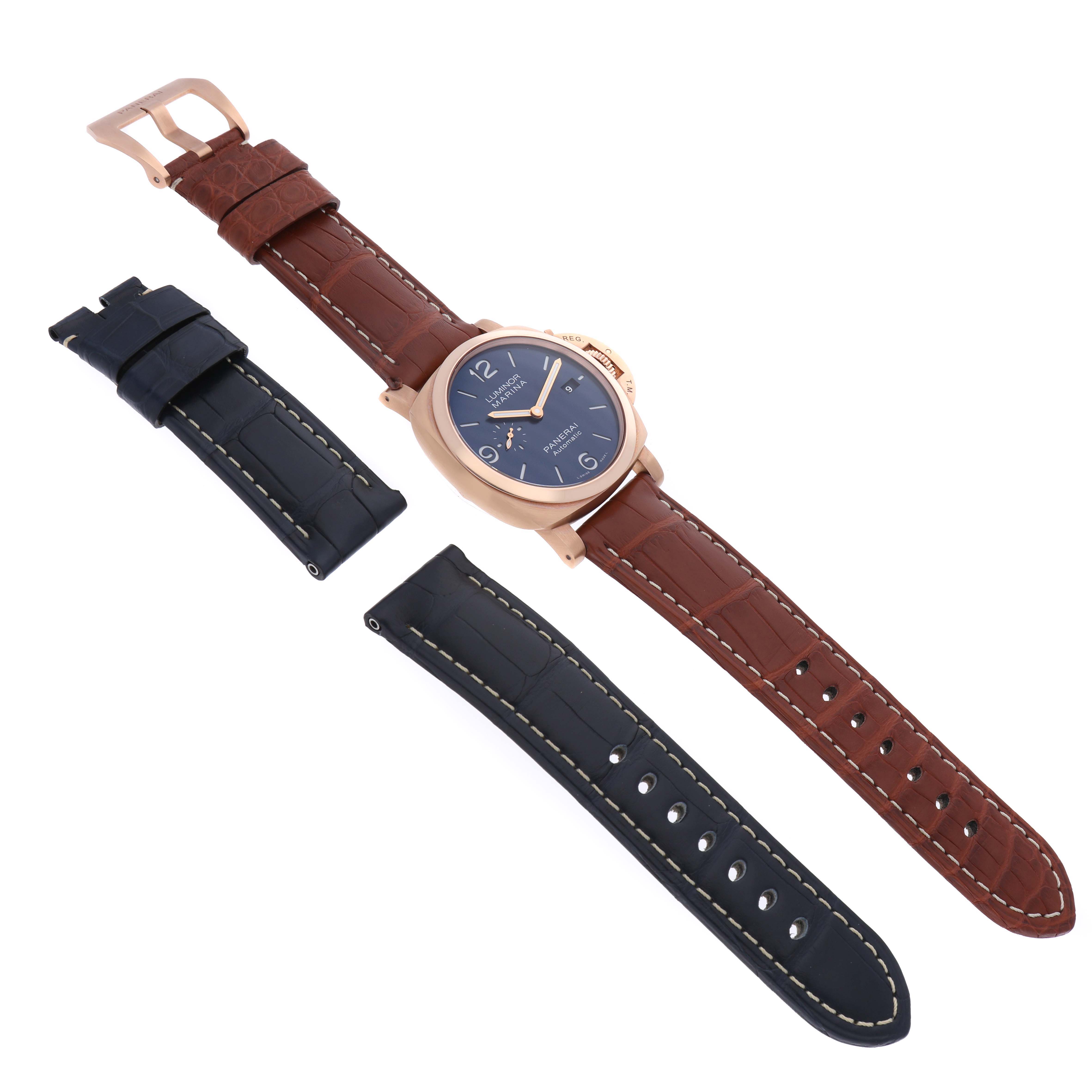 The image shows a Panerai Luminor PAM01112 Men
s Rose Gold Blue Dial PAM01112 Men
s Rose Gold Blue Dial watch with a brown leather strap, accompanied by an additional set of black leather straps, displayed from a top-down angle.