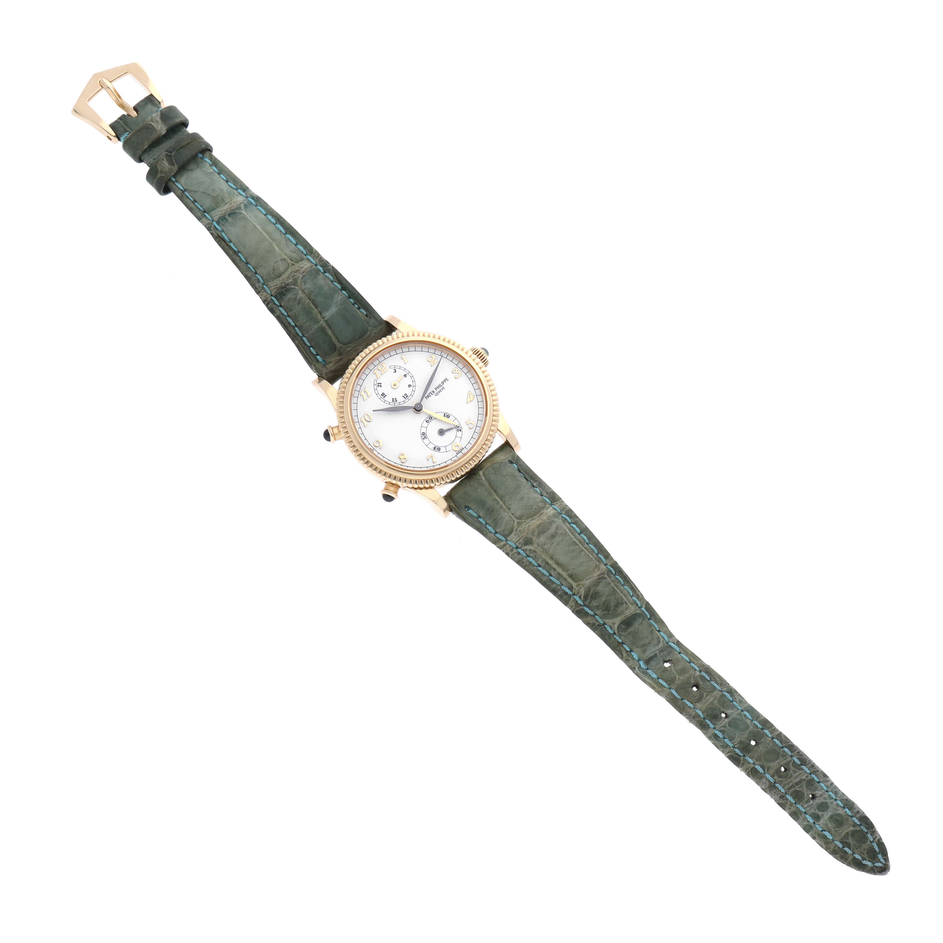 This image shows a top-down view of a Patek Philippe Calatrava 4864J-001 Women's Yellow Gold White Dial 4864J-001 Women's Yellow Gold White Dial watch with a green strap and gold case.