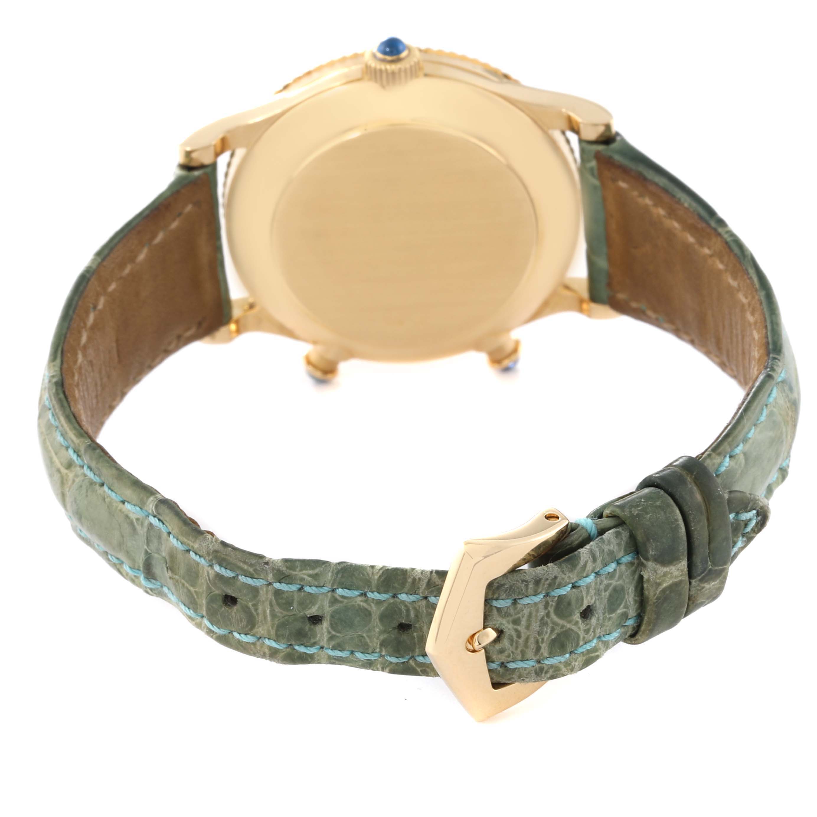 This is the rear view of a Patek Philippe Calatrava 4864J-001 Women's Yellow Gold White Dial 4864J-001 Women's Yellow Gold White Dial watch showing the case back, crown, and green leather strap with a buckle.