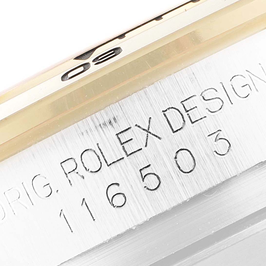 This close-up of the Rolex Daytona 116503 Men
s Steel and Gold (two tone) White Dial 116503 Men
s Steel and Gold (two tone) White Dial watch shows the engraved model number and part of the bezel.