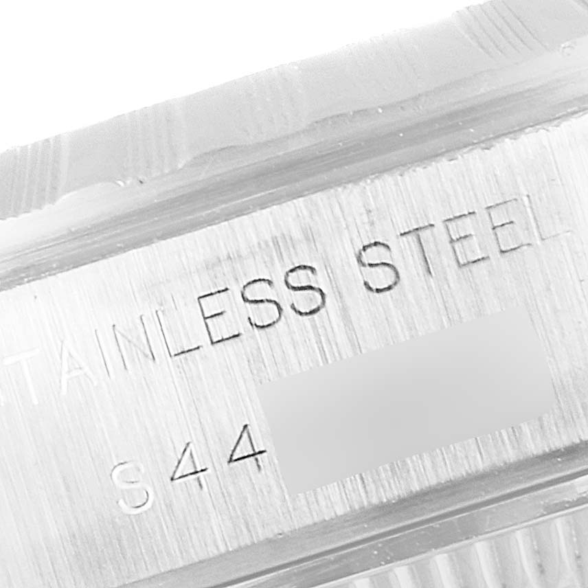 This image shows a close-up of the case side engraving on a Rolex Date 69240 Women's Stainless Steel Black Dial 69240 Women's Stainless Steel Black Dial model, highlighting the words "STAINLESS STEEL" and a serial number.