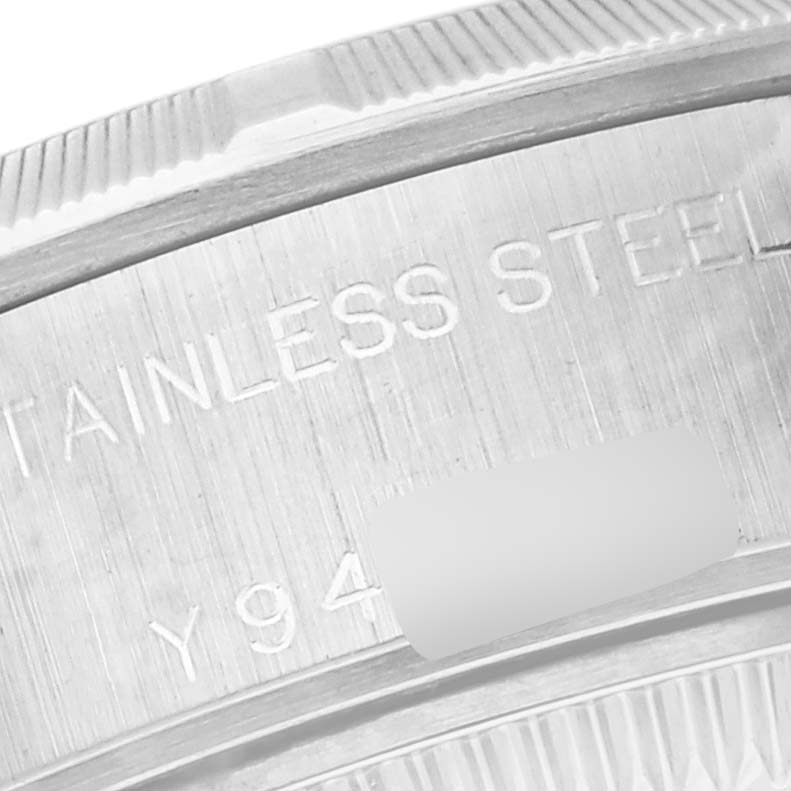 This close-up image of a Rolex Date 79190 Women's Stainless Steel Pink Dial 79190 Women's Stainless Steel Pink Dial model watch shows the engraved stainless steel caseback and partial view of the bezel.