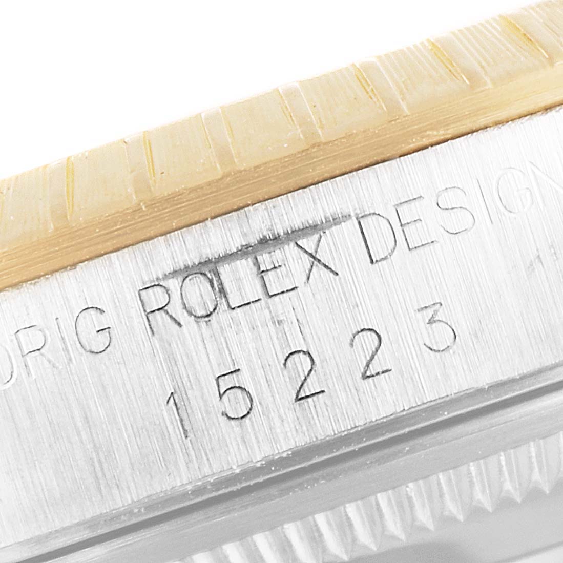 Close-up of the engraved side of a Rolex Date 15223 Men's Steel and Gold (two tone) Silver Dial 15223 Men's Steel and Gold (two tone) Silver Dial model, showing model number 15223 and part of the bezel.