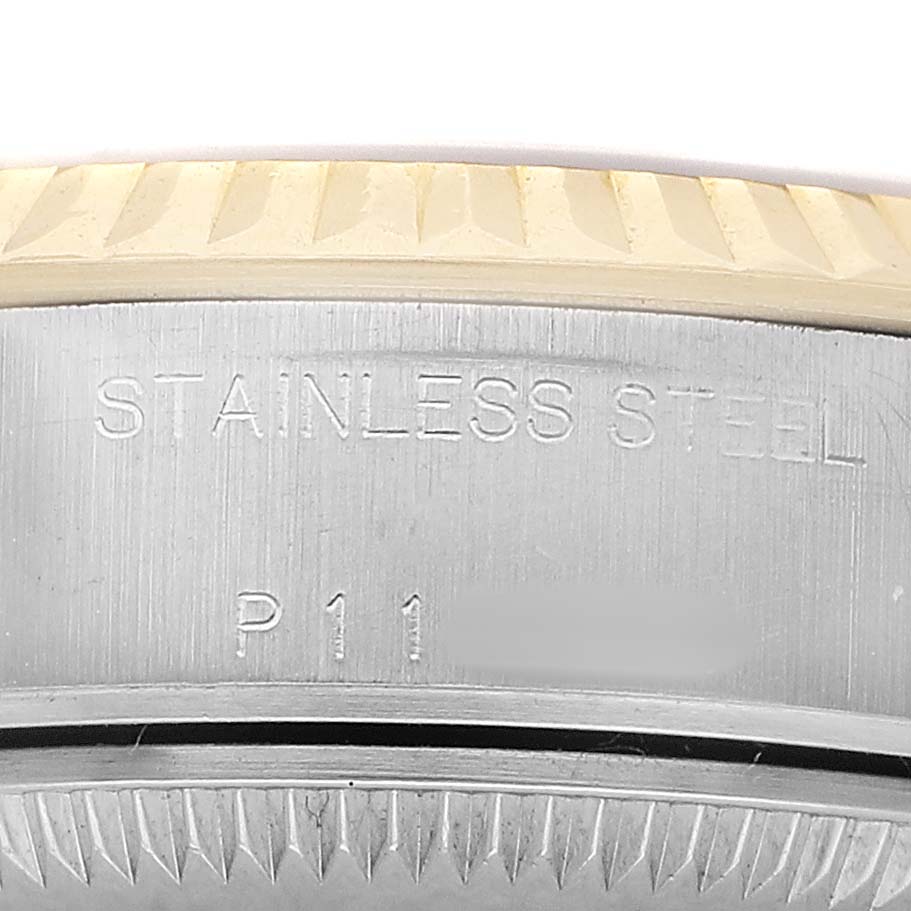 The image shows a close-up of the Datejust Rolex's case edge with visible engravings and part of the fluted bezel.