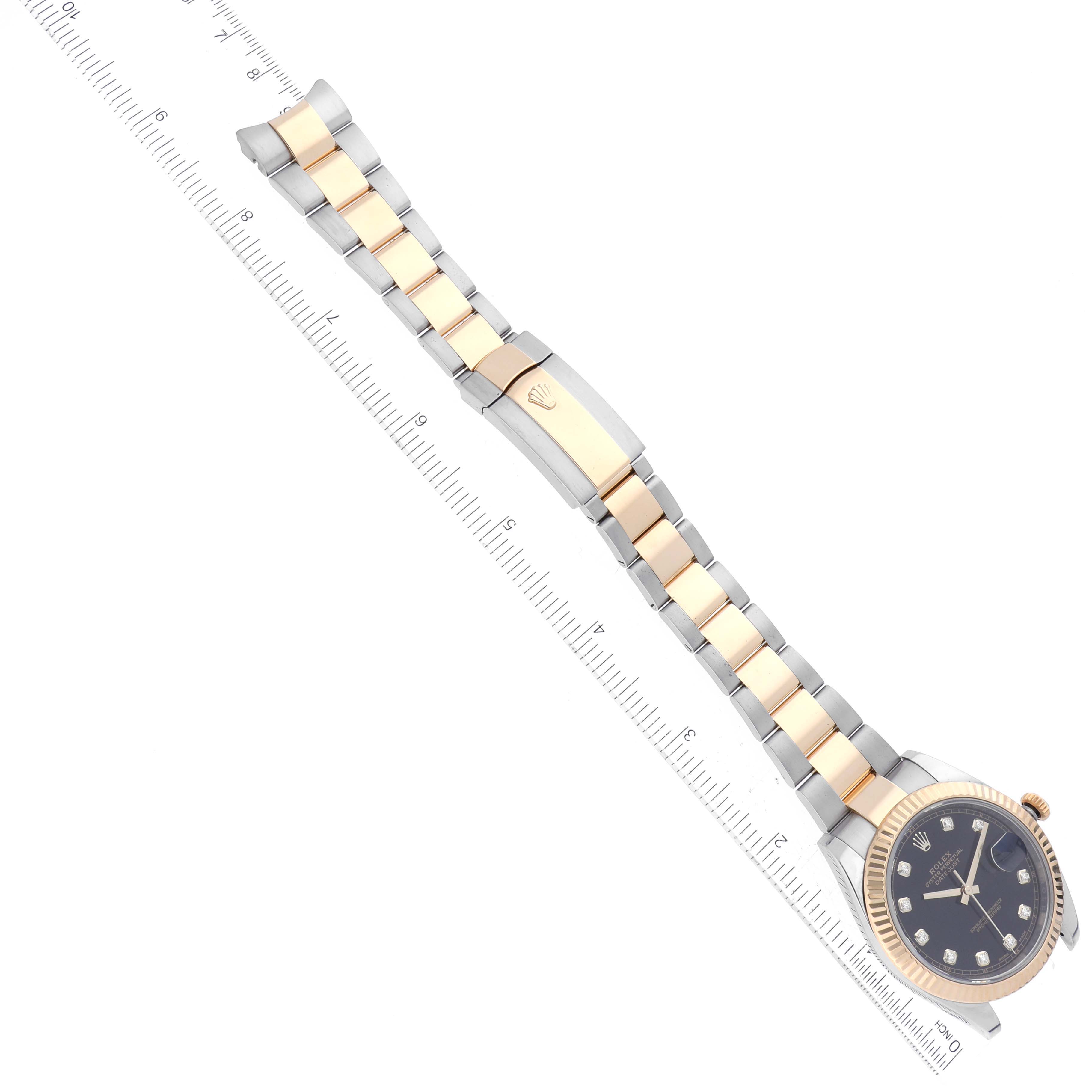 This image shows a Rolex Datejust 41 126333 Men's Steel and Gold (two tone) Black Dial 126333 Men's Steel and Gold (two tone) Black Dial watch at an angled top view, highlighting its band, face, and clasp next to a ruler.