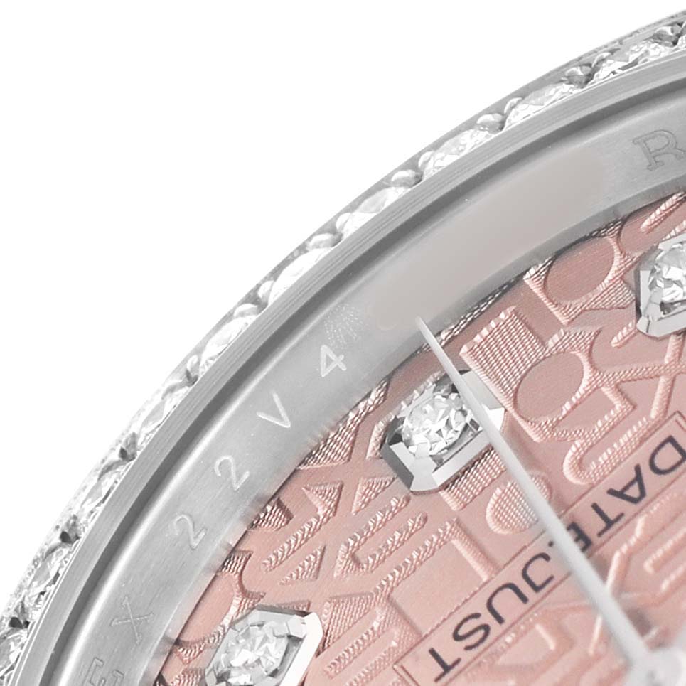 This close-up of the Rolex Datejust 126284 Men's Stainless Steel Pink Dial watch shows the bezel, part of the dial, and diamond hour markers on a patterned surface.