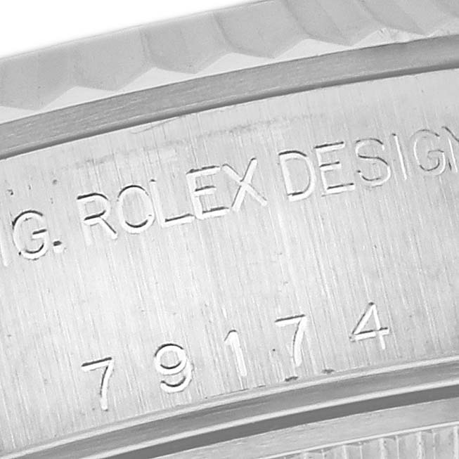 The image shows an engraved close-up of the side of a Rolex Datejust 79174 Women's Stainless Steel White Dial 79174 Women's Stainless Steel White Dial watch case, featuring the model number and "ROLEX DESIGN" text.
