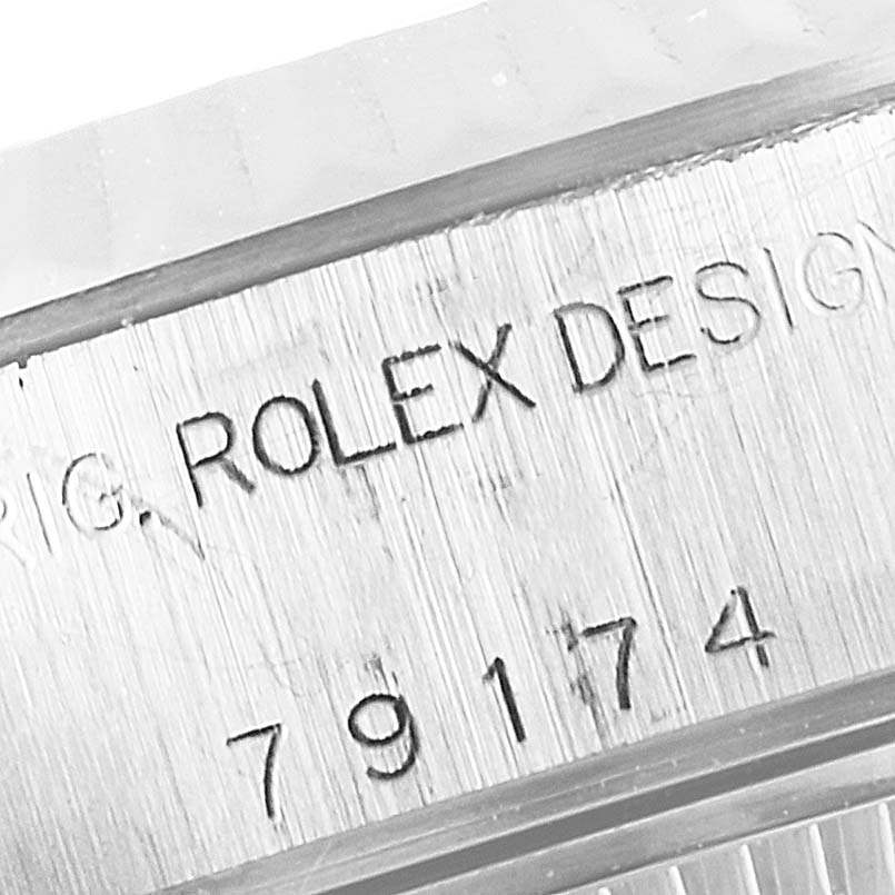 This close-up image shows the serial number and "ROLEX DESIG" engraving on the case of a Rolex Datejust 79174 Women
s Stainless Steel Silver Dial 79174 Women
s Stainless Steel Silver Dial watch.