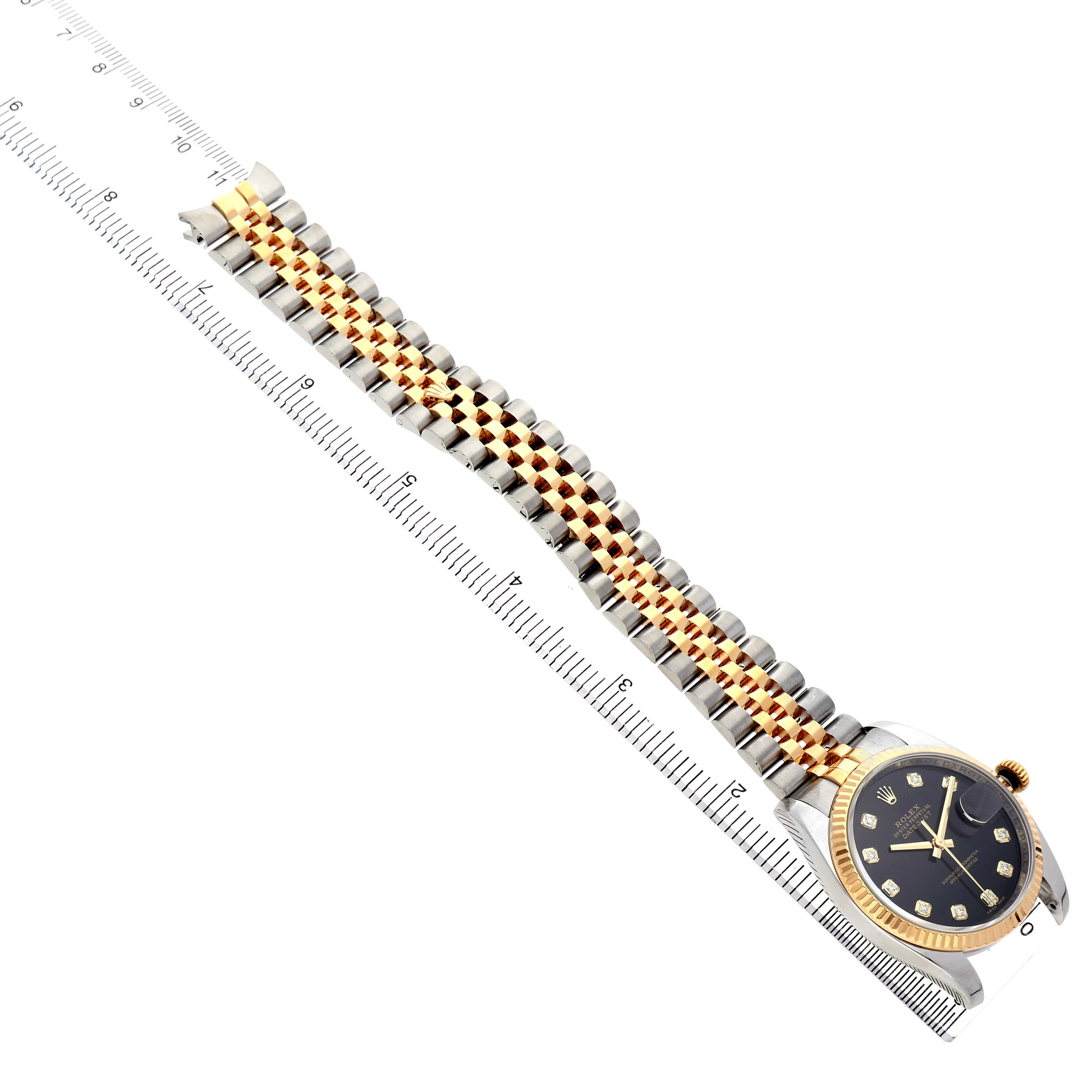 The Rolex Datejust 116233 Men's Stainless Steel Black Dial watch is shown at an angle displaying the dial, bezel, and two-tone bracelet alongside a ruler.