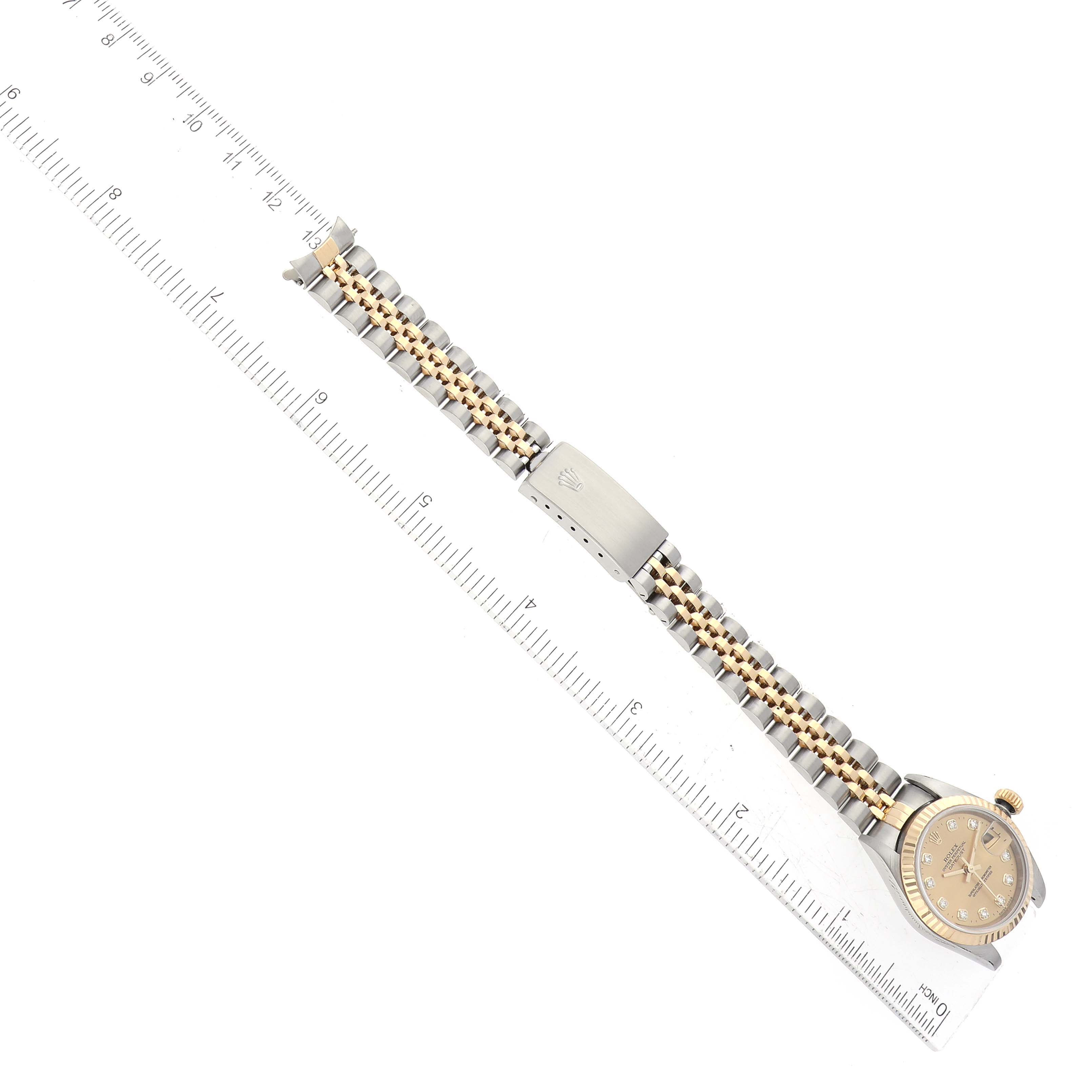 The image shows a Rolex Datejust 79173 Women's Steel and Gold (two tone) Champagne Dial 79173 Women's Steel and Gold (two tone) Champagne Dial watch laid flat with its bracelet and clasp visible, positioned next to a ruler for scale.