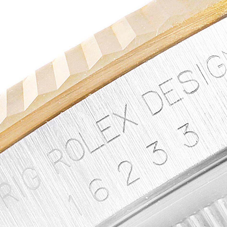 A close-up of the engraving on the side of a Rolex Datejust 16233 Men's Steel and Gold (two tone) Mother of Pearl Dial 16233 Men's Steel and Gold (two tone) Mother of Pearl Dial model, showing the watch’s bezel and part of the engraved text.