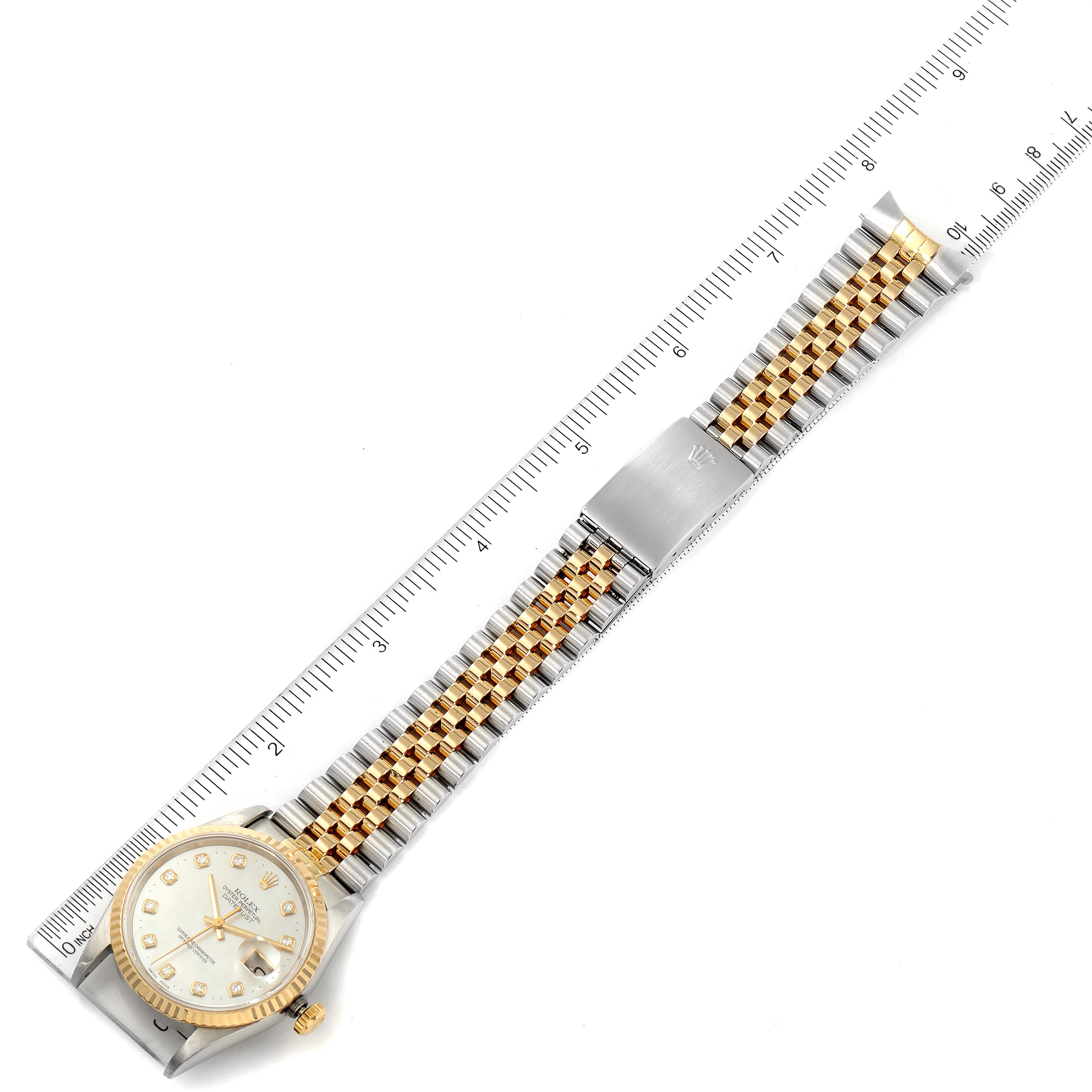 This image shows a Rolex Datejust 16233 Men's Steel and Gold (two tone) Mother of Pearl Dial 16233 Men's Steel and Gold (two tone) Mother of Pearl Dial watch laid flat with its dial and Jubilee bracelet visible, measured alongside a ruler.