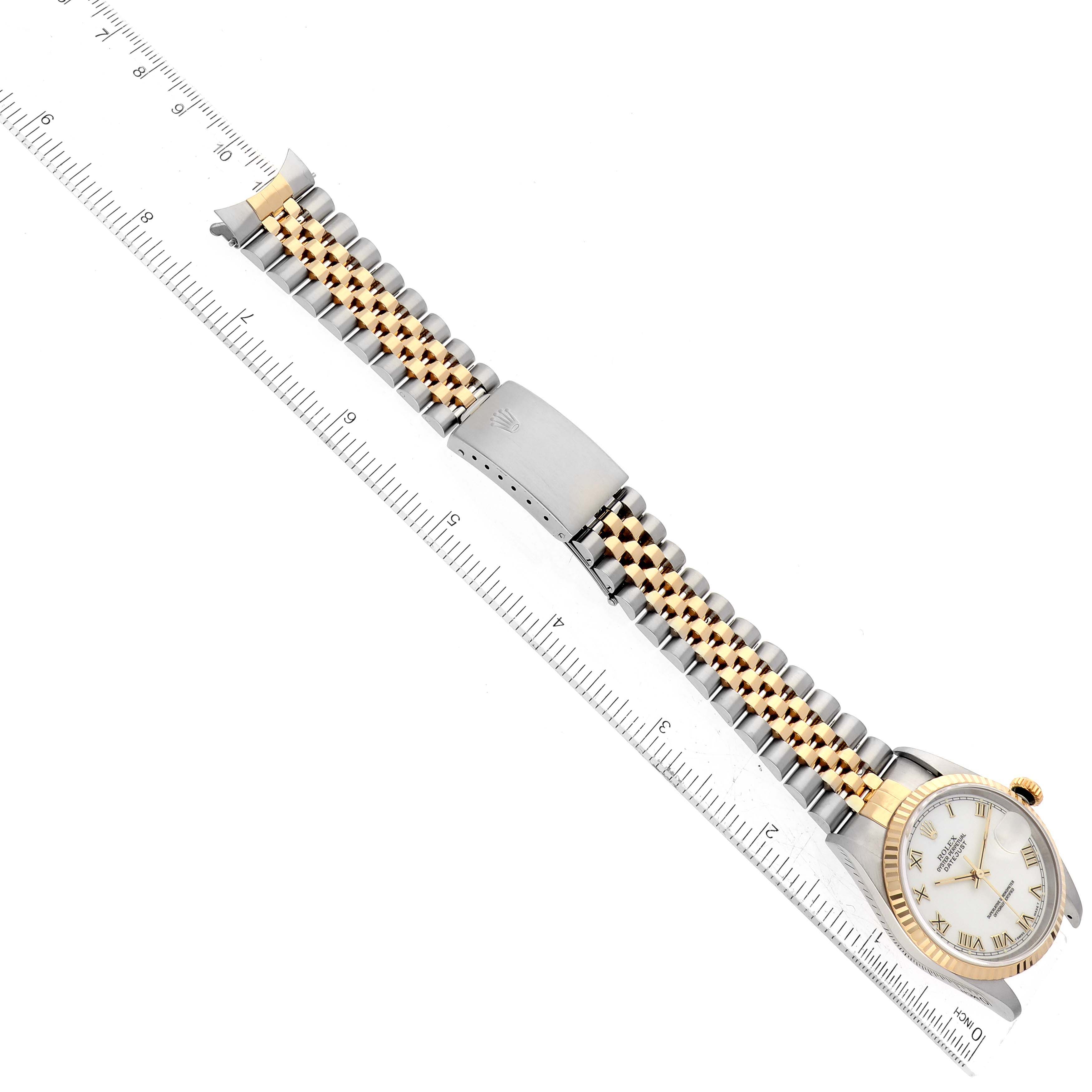 The image shows a Rolex Datejust 16233 Men's Steel and Gold (two tone) White Dial 16233 Men's Steel and Gold (two tone) White Dial watch angled diagonally, highlighting the face, bezel, and two-tone bracelet laid alongside a ruler.
