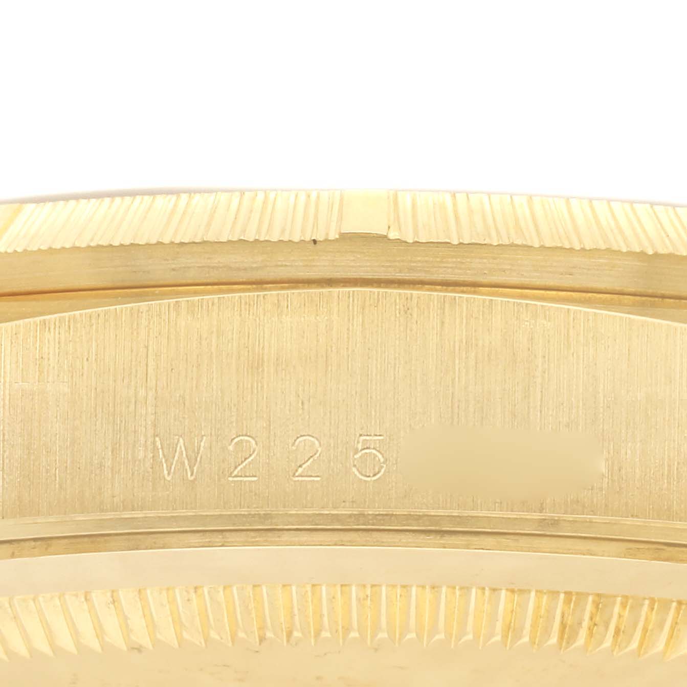 This close-up image shows the serial number engraving on the case of a Rolex President 18248 Men's Yellow Gold Champagne Dial 18248 Men's Yellow Gold Champagne Dial model watch.