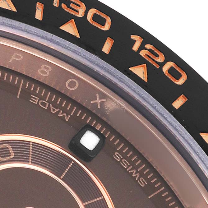 The image shows a close-up of the bezel and dial edge of a Rolex Daytona 116515 Men's Rose Gold Brown Dial watch, highlighting the tachymetric scale.