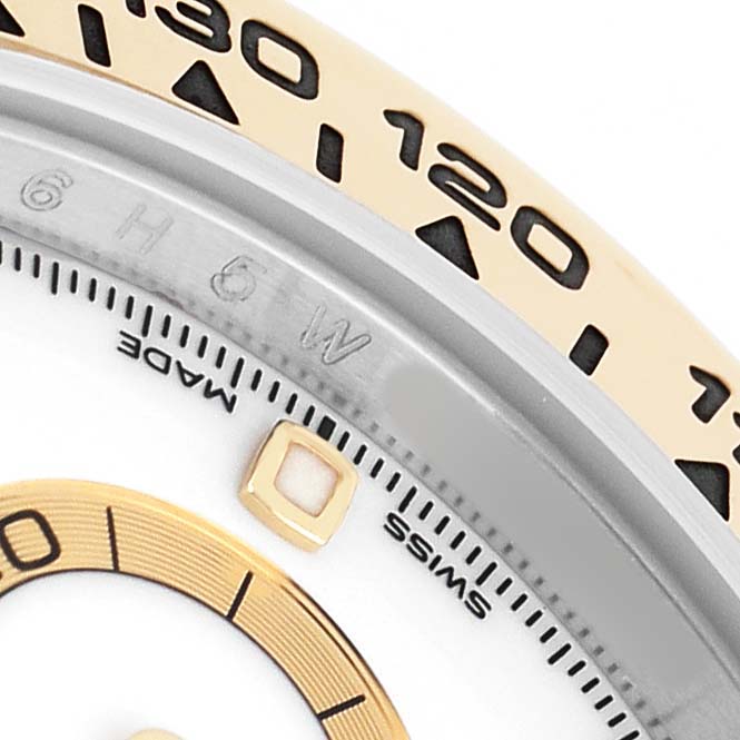 The image shows a close-up of the Rolex Daytona 116503 Men's Steel and Gold (two tone) White Dial's bezel and a portion of the dial with gold accents and indices.