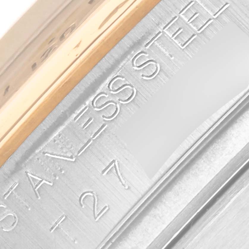 This image shows a close-up angle of the engraved text "STAINLESS STEEL" on the side of a Rolex Daytona 16523 Men's Steel and Gold (two tone) Black Dial 16523 Men's Steel and Gold (two tone) Black Dial watch case.
