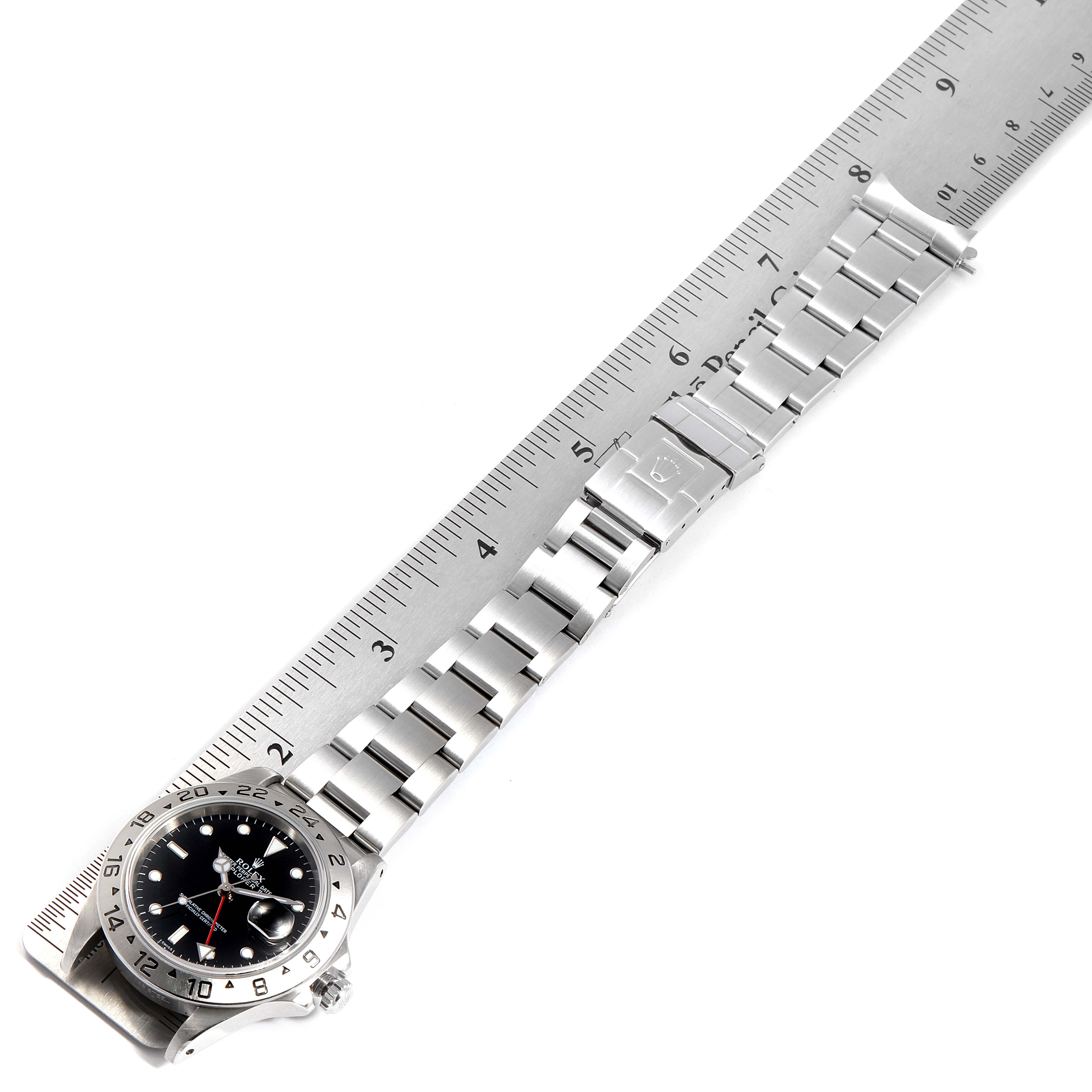 The image shows a Rolex Explorer 16570 Men
s Stainless Steel Black Dial 16570 Men
s Stainless Steel Black Dial watch laid flat, with its stainless steel band measured along a ruler.