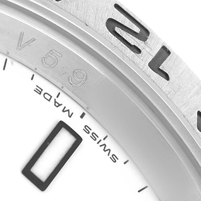 The image shows a close-up of the bezel and part of the dial of a Rolex Explorer 16570 Men's Stainless Steel White Dial watch, highlighting details like engravings.