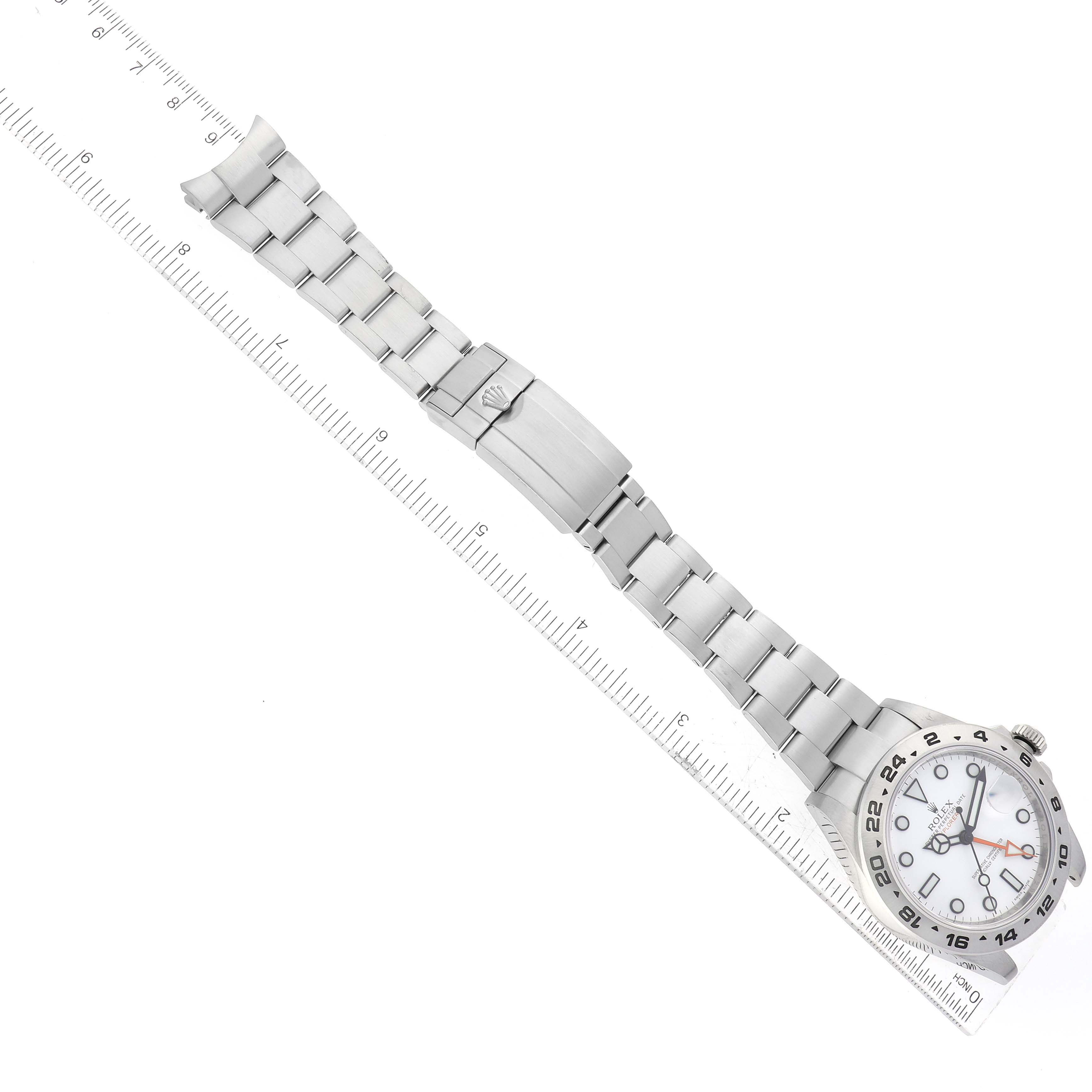 The image shows a top view of a Rolex Explorer 216570 Men's Stainless Steel White Dial 216570 Men's Stainless Steel White Dial watch, with the dial, bezel, bracelet, and clasp fully visible, alongside a measuring ruler.