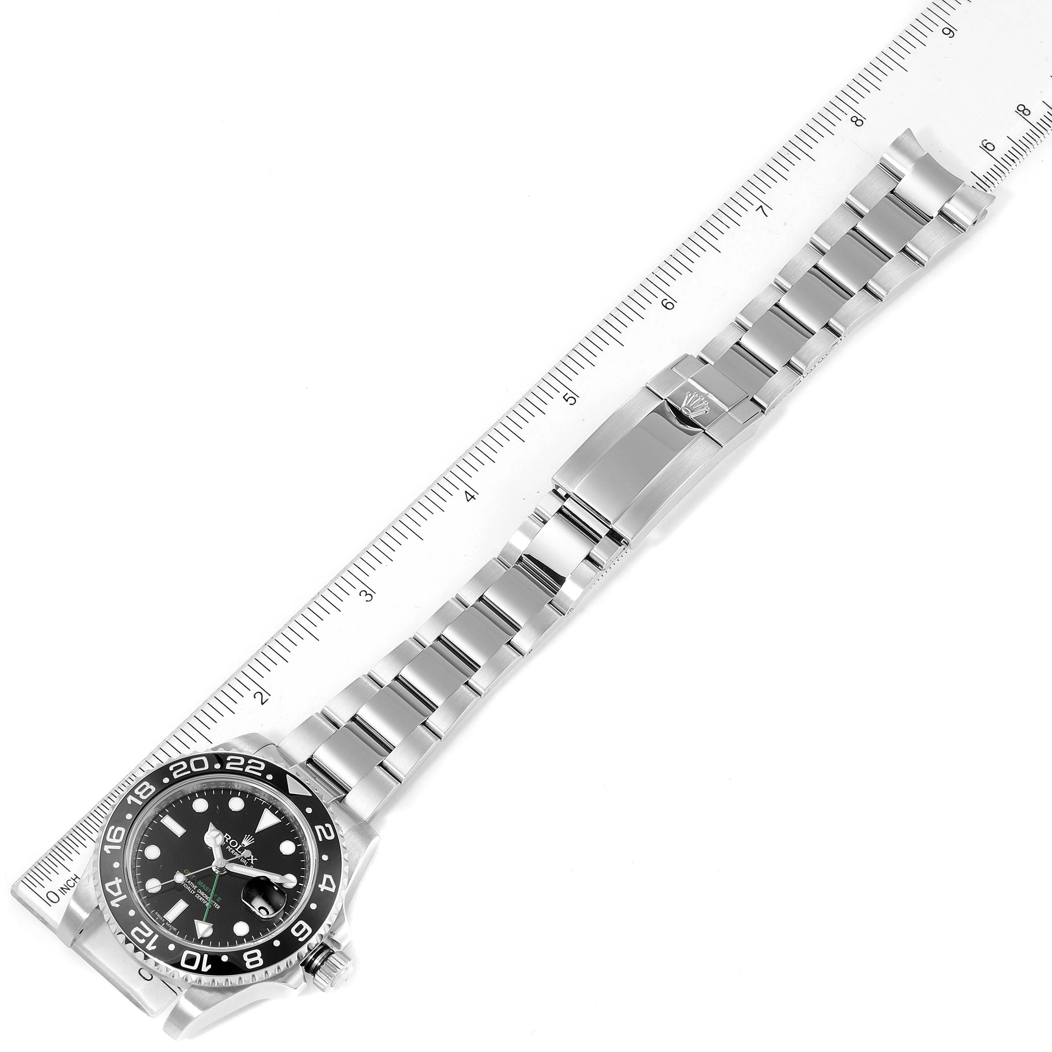 This image shows a Rolex GMT-Master 116710 Men's Stainless Steel Black Dial 116710 Men's Stainless Steel Black Dial watch laid flat, with the bracelet extended and a ruler positioned alongside it for measurement.