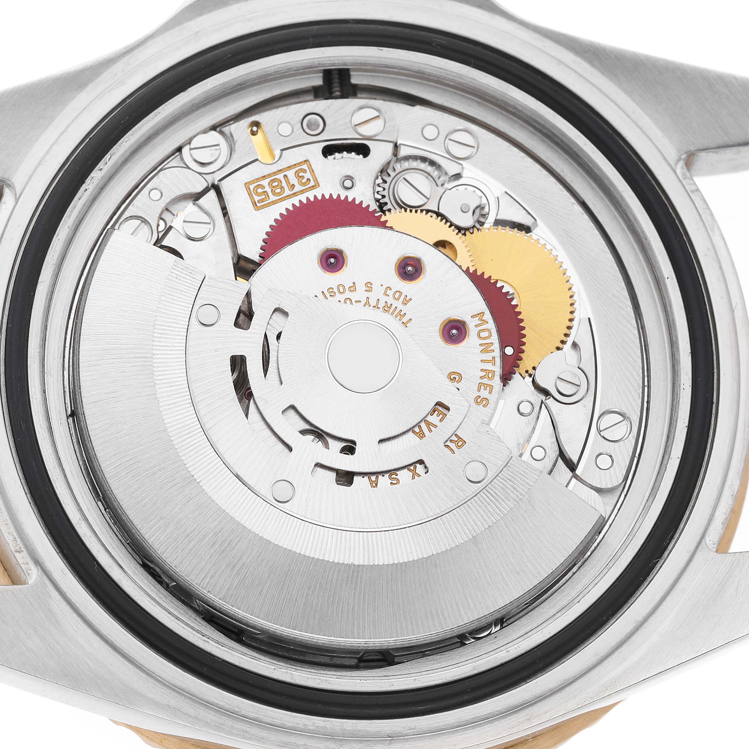 The image shows the movement of a Rolex GMT-Master 16713 Men's Steel and Gold (two tone) Brown Dial watch, featuring its intricate gears and rotors.