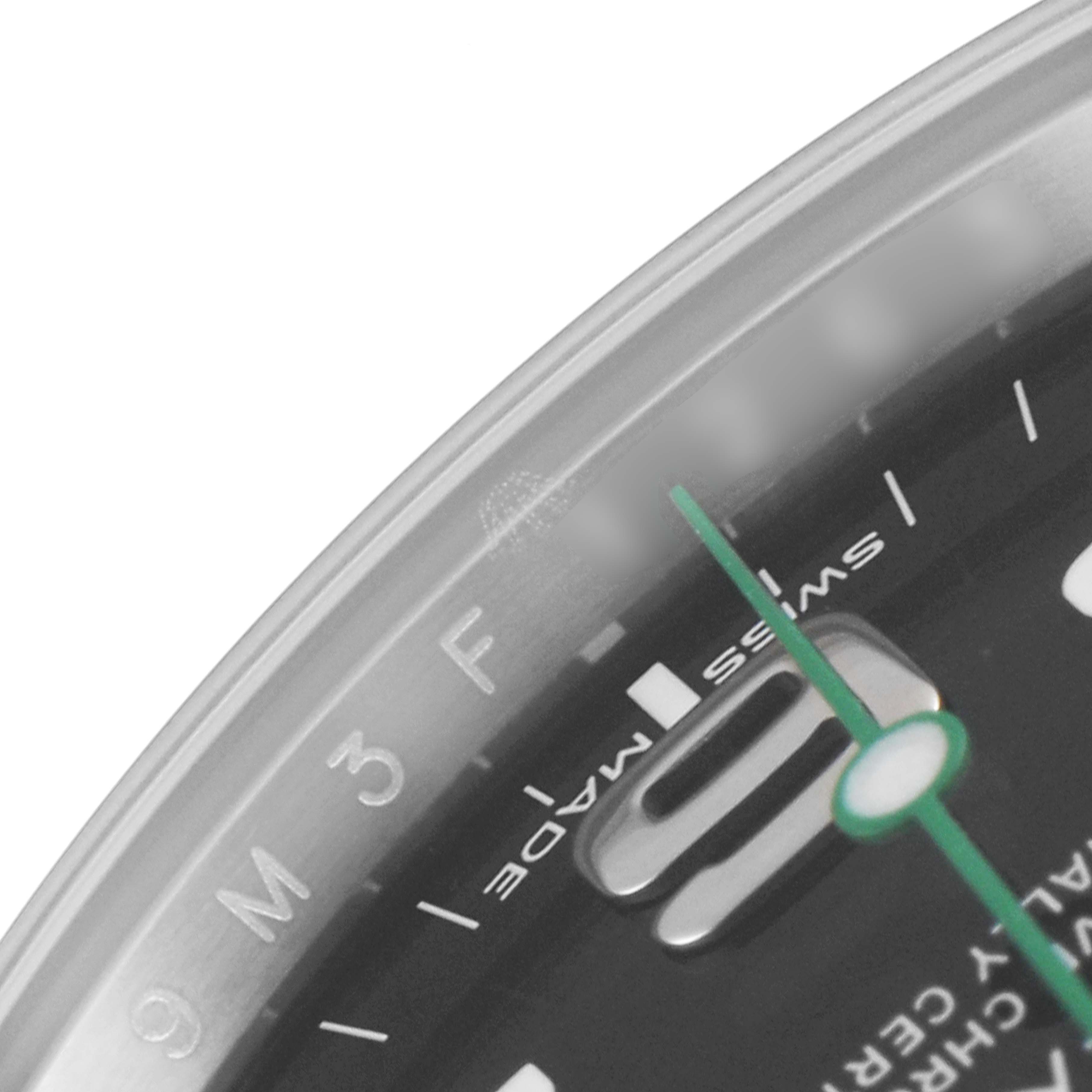 This close-up image of the Rolex Air-King 116900 Men's Stainless Steel Black Dial 116900 Men's Stainless Steel Black Dial watch shows part of the dial, minute markers, and the green second hand.