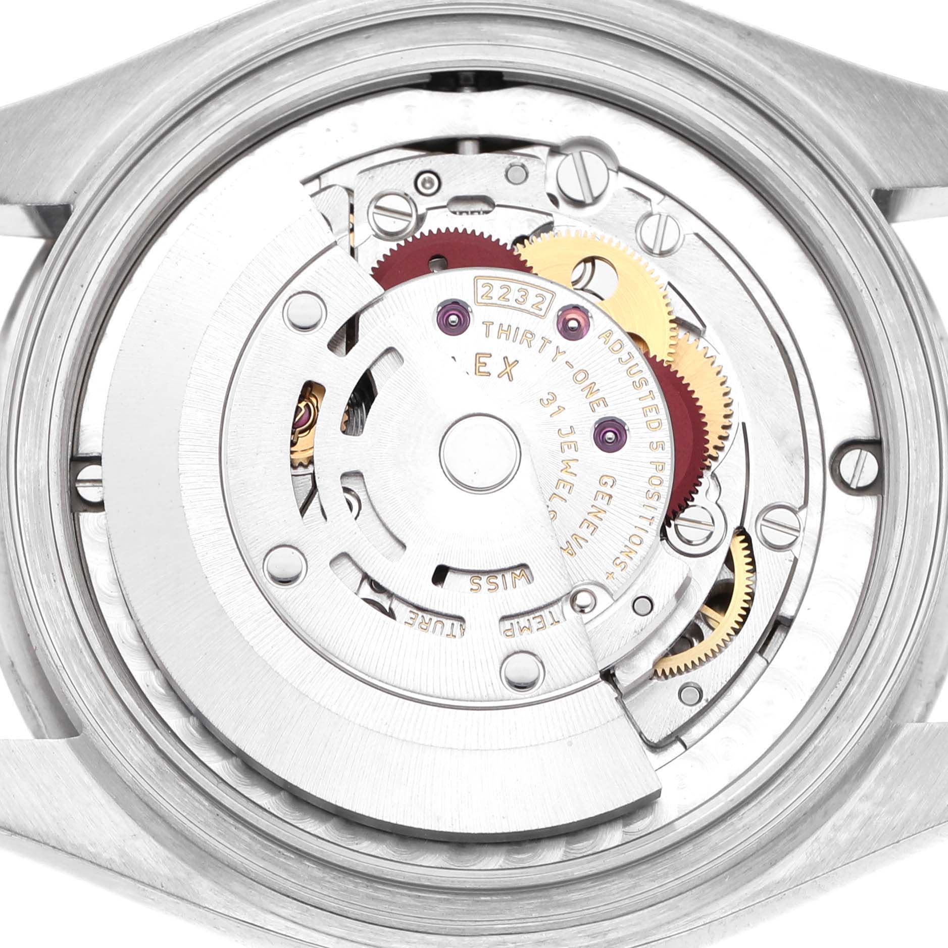 The image shows the internal movement of a mid-size Rolex watch from a top-down angle, highlighting its gears and rotor.