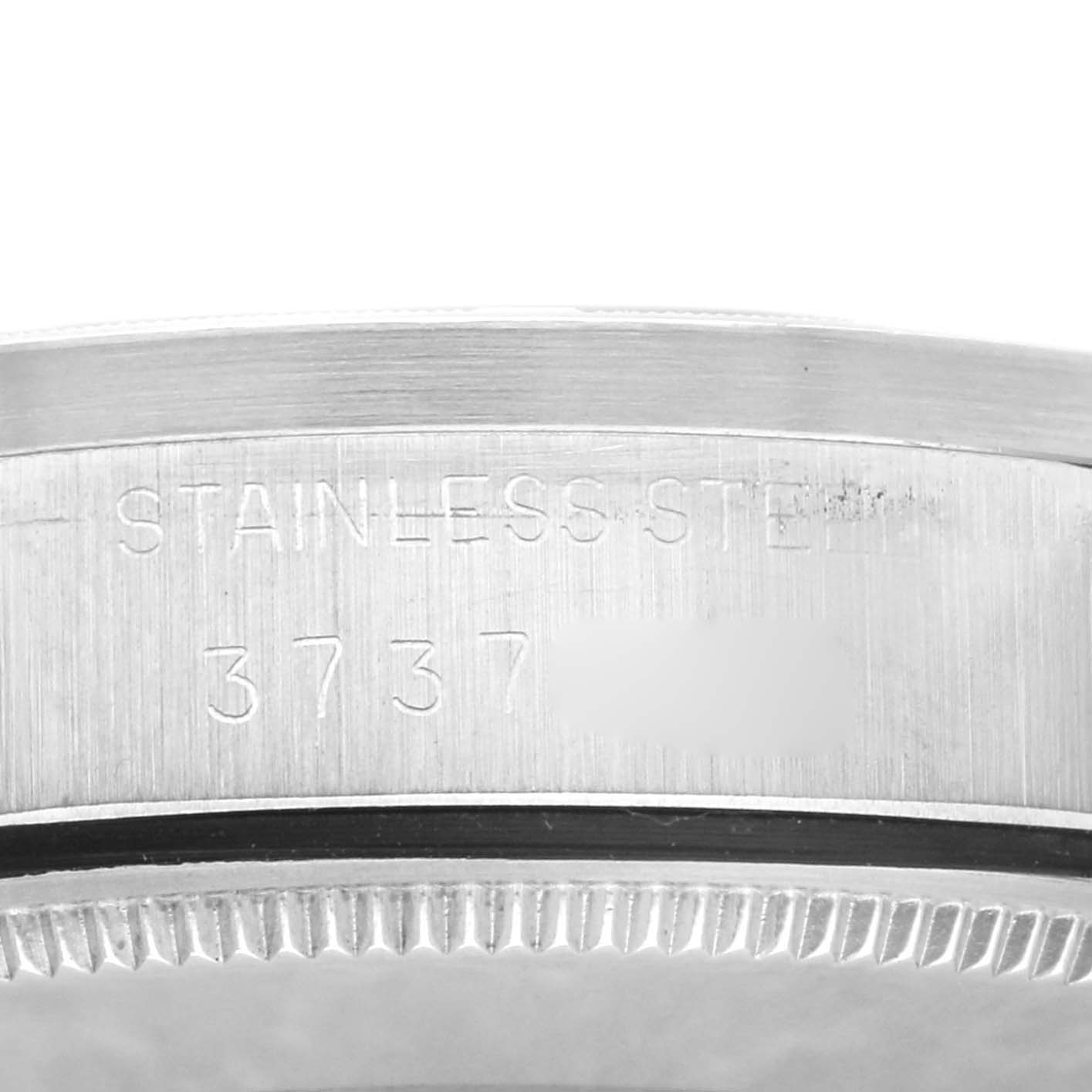 This close-up image shows the engraved side of the bezel of a Rolex Vintage Collection 1007 Men's Stainless Steel Silver Dial 1007 Men's Stainless Steel Silver Dial watch, highlighting its stainless steel material.