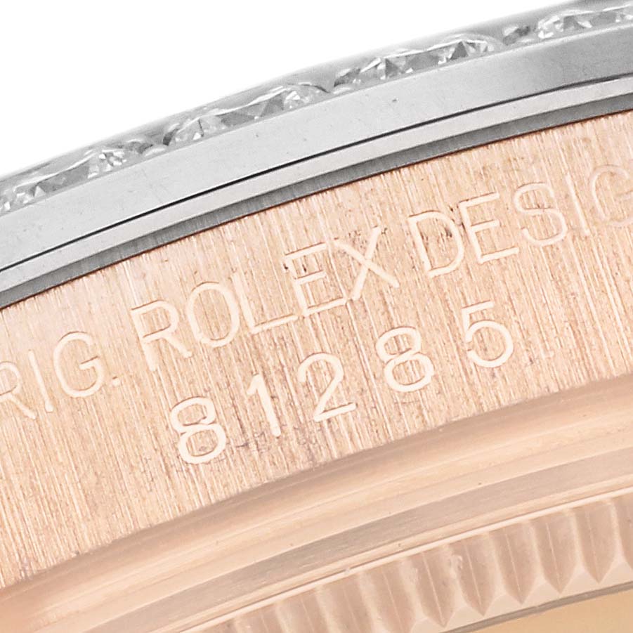 This close-up image shows the engraved serial number and part of the bezel of a Rolex Pearlmaster 81285 Women's Rose Gold Pink Dial 81285 Women's Rose Gold Pink Dial watch.