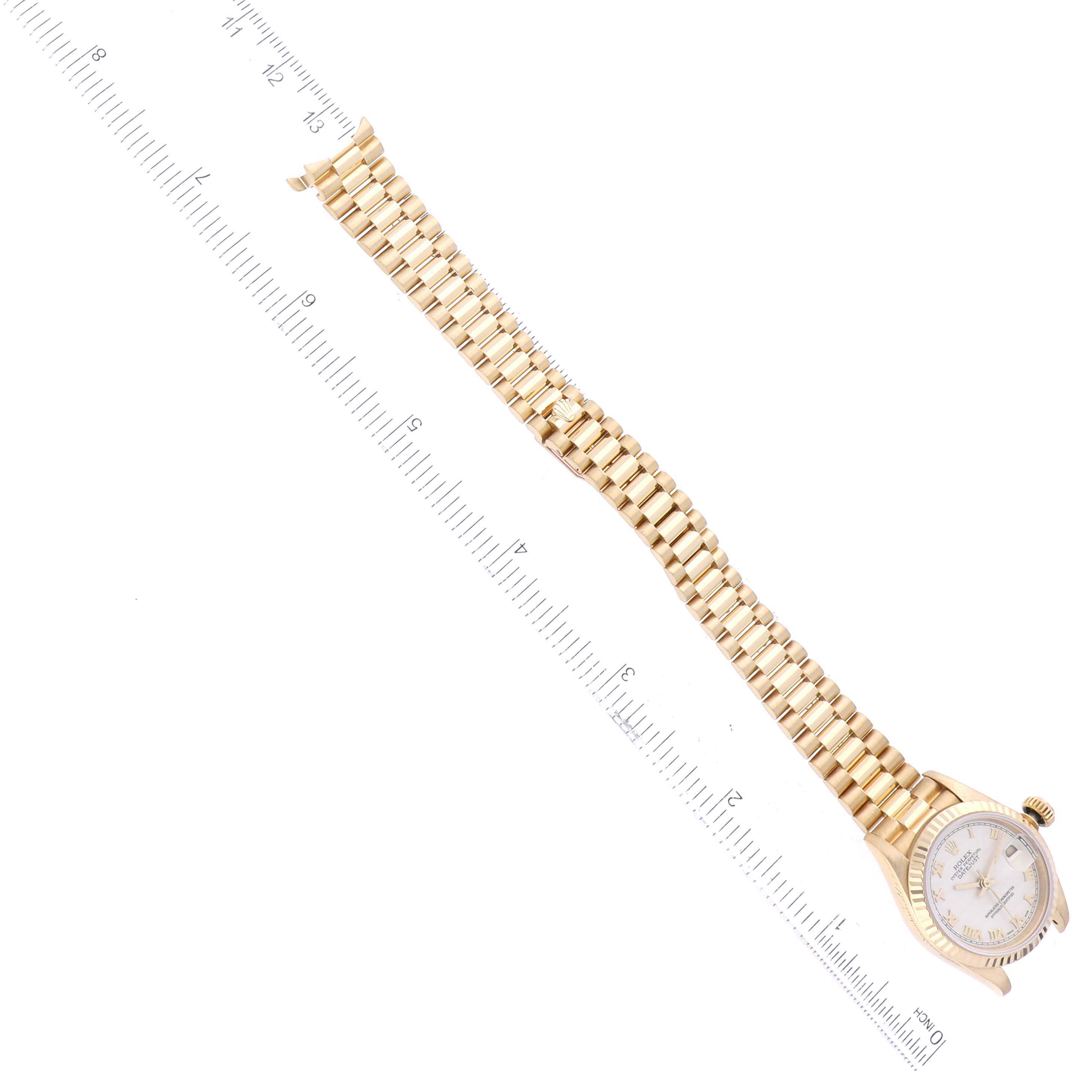 The image shows a Rolex President 69178 Women's Yellow Gold Silver Dial 69178 Women's Yellow Gold Silver Dial watch, angled diagonally, with its gold band and face displayed alongside a ruler.