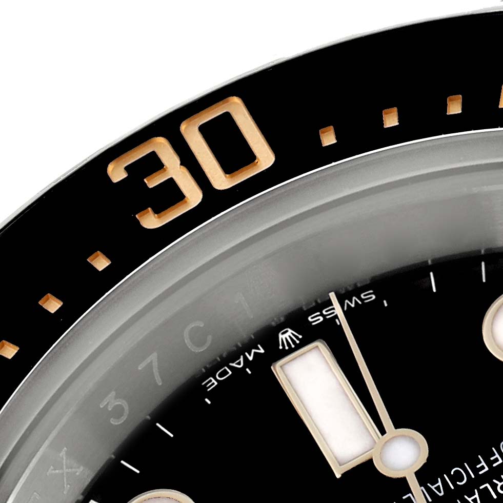 The close-up image of the Rolex Sea-Dweller 126603 Men
s Steel and Gold (two tone) Black Dial shows part of the bezel with the "30" mark and a portion of the dial with an hour marker.