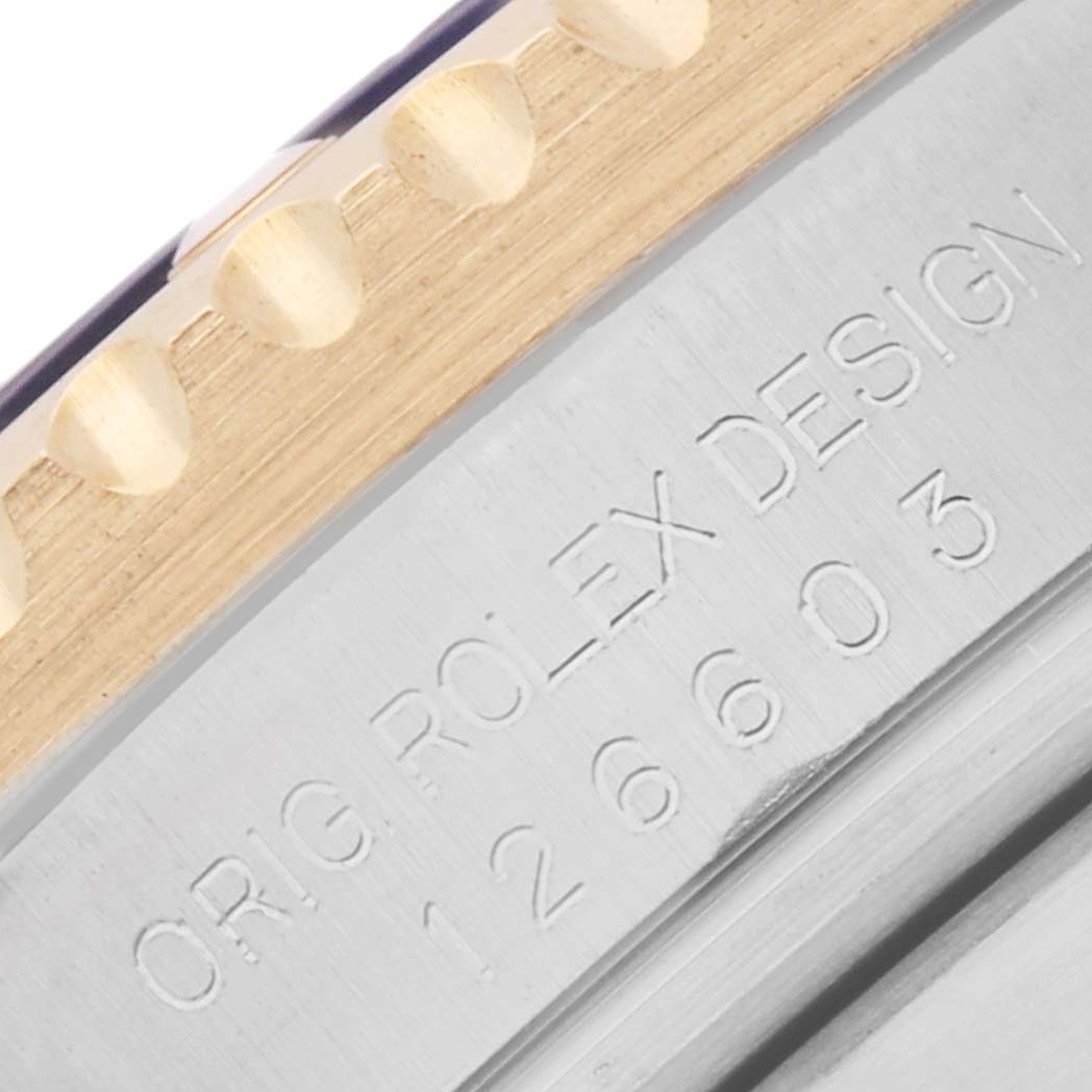 The image shows a close-up angle of the Rolex Sea-Dweller 126603 Men
s Steel and Gold (two tone) Black Dial
s engraved case side with part of the bezel visible.