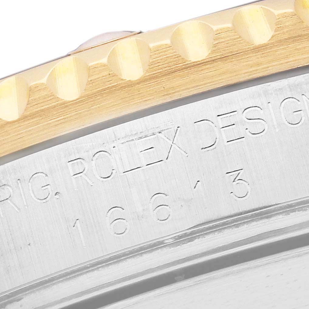 The image shows a close-up angle of the engraved side and bezel of the Rolex Submariner 16613 Men's Steel and Gold (two tone) Blue Dial 16613 Men's Steel and Gold (two tone) Blue Dial watch.