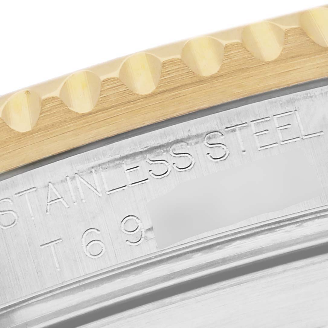 This close-up angle of the Rolex Submariner 16613 Men's Steel and Gold (two tone) Blue Dial 16613 Men's Steel and Gold (two tone) Blue Dial shows the edge of the bezel and part of the engraved stainless steel case.