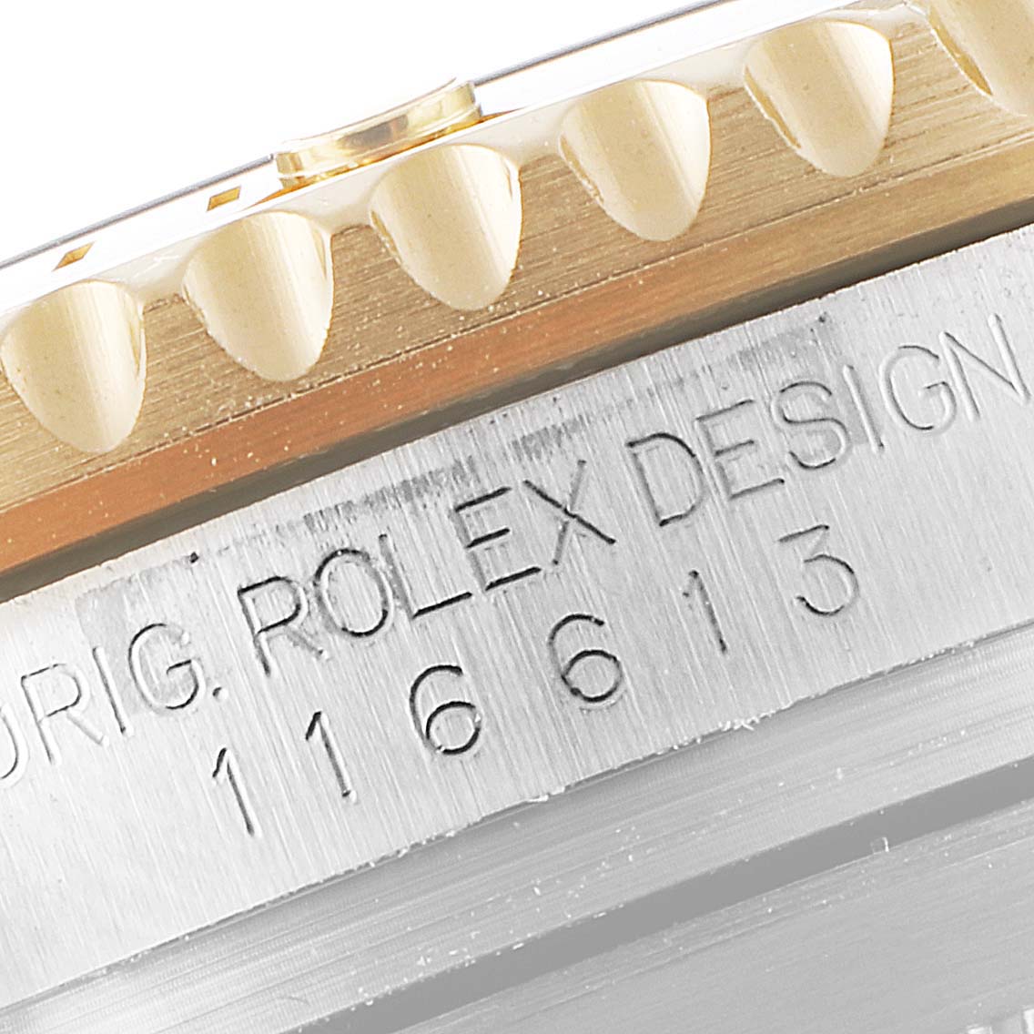 This close-up image shows the engraving and toothed bezel of a Rolex Submariner 116613 Men
s Steel and Gold (two tone) Black Dial 116613 Men
s Steel and Gold (two tone) Black Dial model.