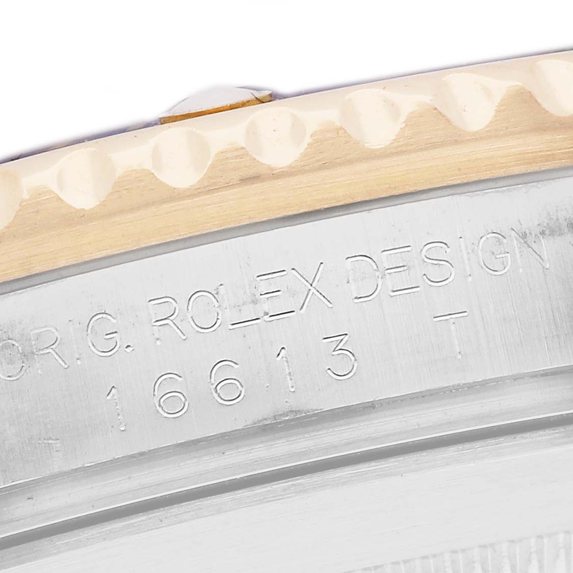 The image shows a close-up of the side engraving and bezel edge of a Rolex Submariner 16613 Men
s Steel and Gold (two tone) Grey Dial, featuring its model number.