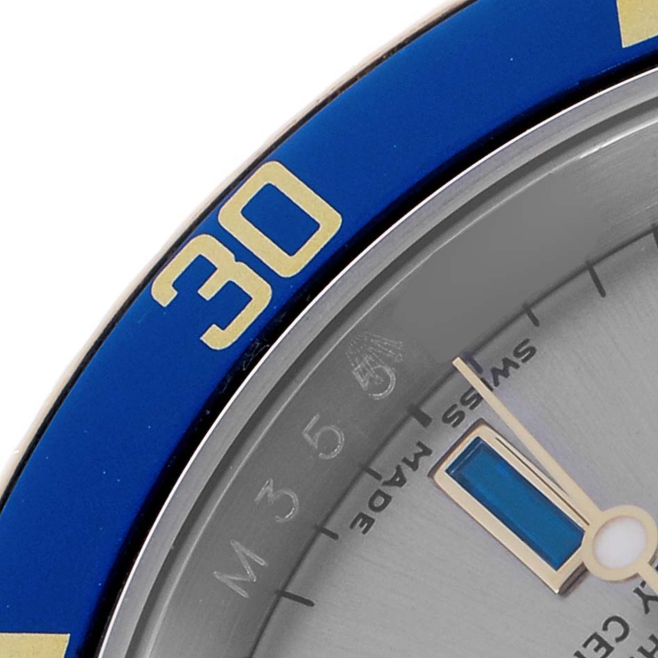The image shows a close-up of the bezel and part of the dial of a Rolex Submariner 16613 Men
s Steel and Gold (two tone) Grey Dial, highlighting the "30" marking on the blue bezel.