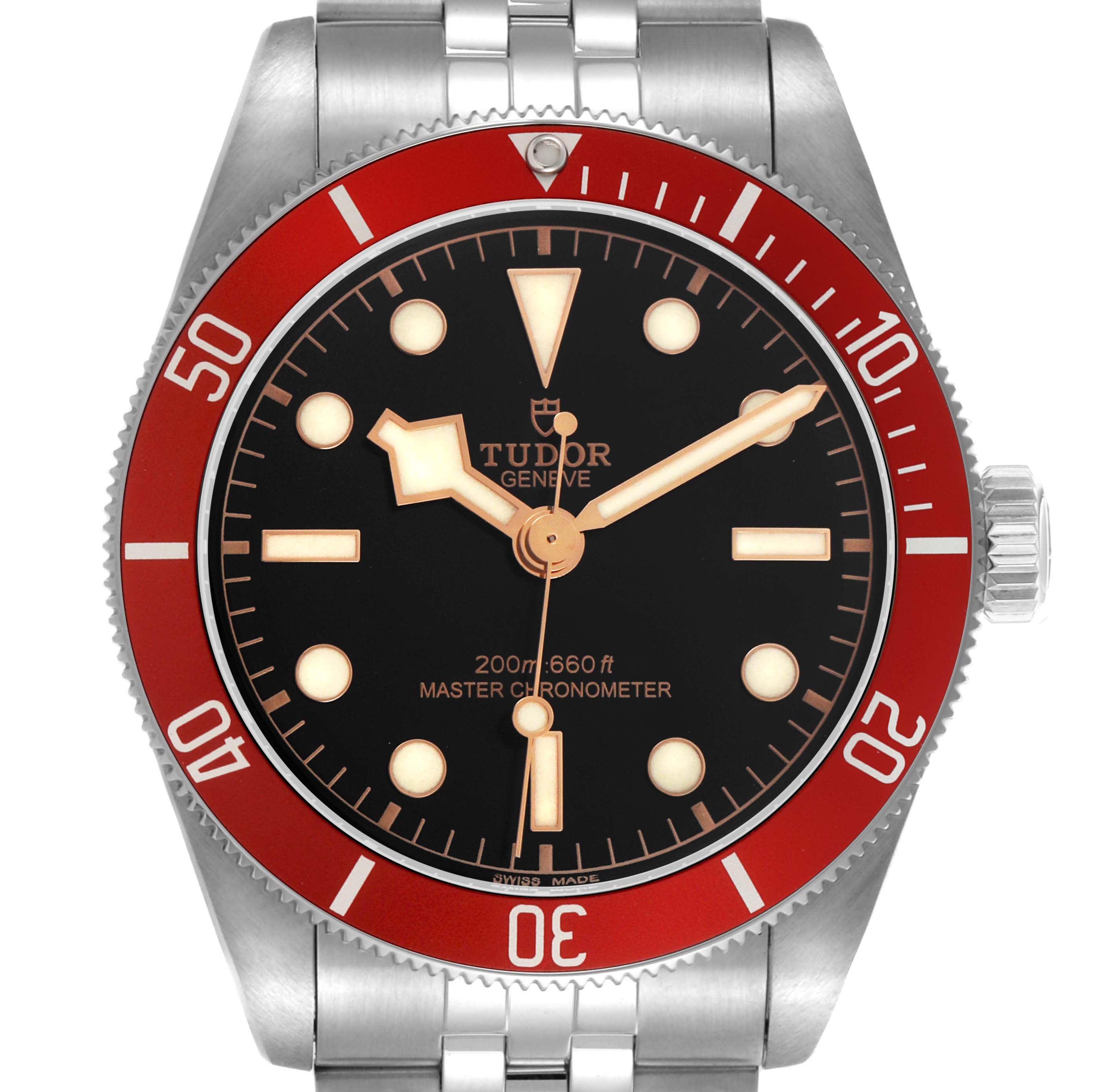 The Tudor Heritage Black Bay 7941A1A0 Men's Stainless Steel Black Dial watch is shown from the front, displaying its dial, red bezel, and part of the bracelet.