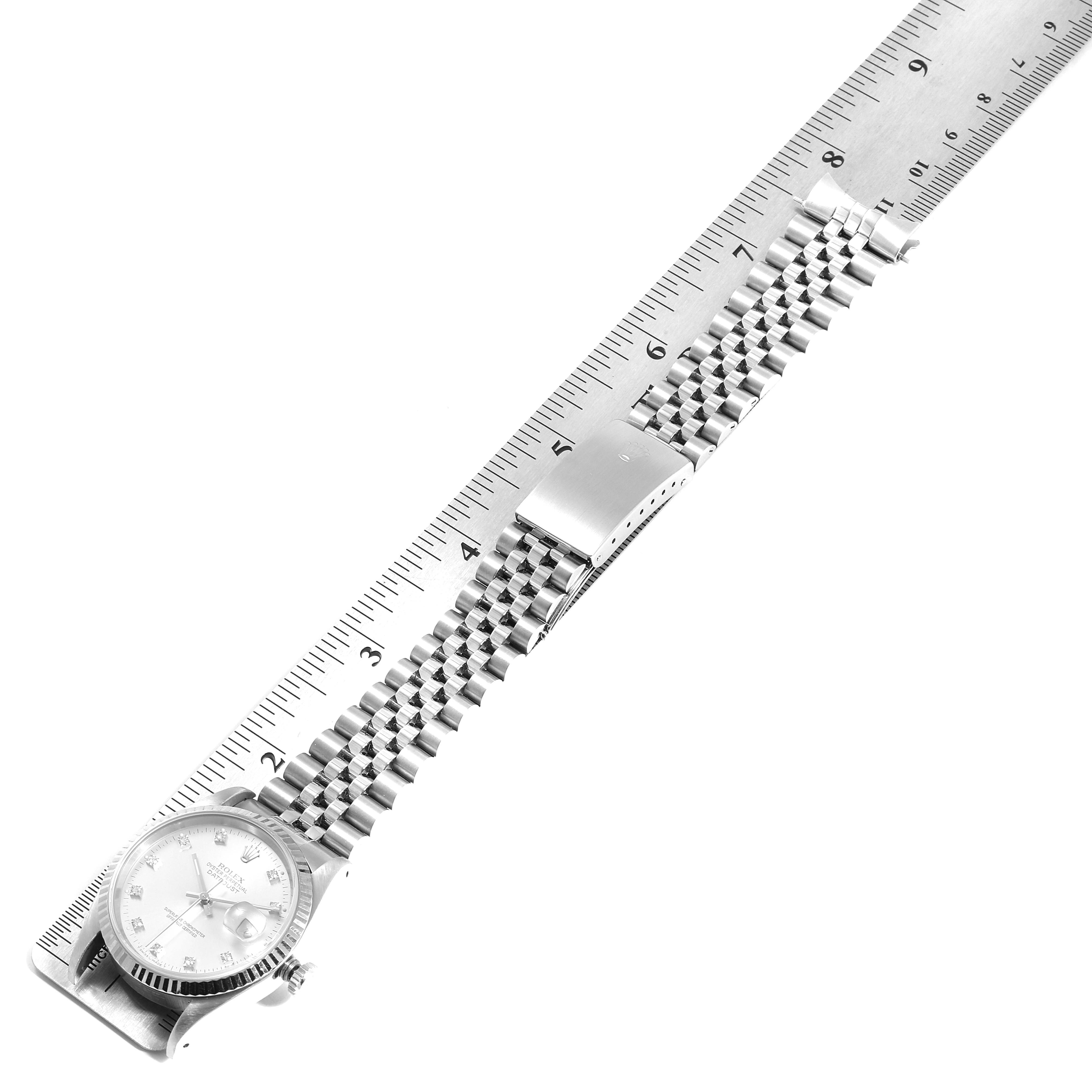 The image shows a top view of a Rolex Datejust 16234 Men's Stainless Steel Silver Dial 16234 Men's Stainless Steel Silver Dial watch with an open stainless steel bracelet next to a ruler.