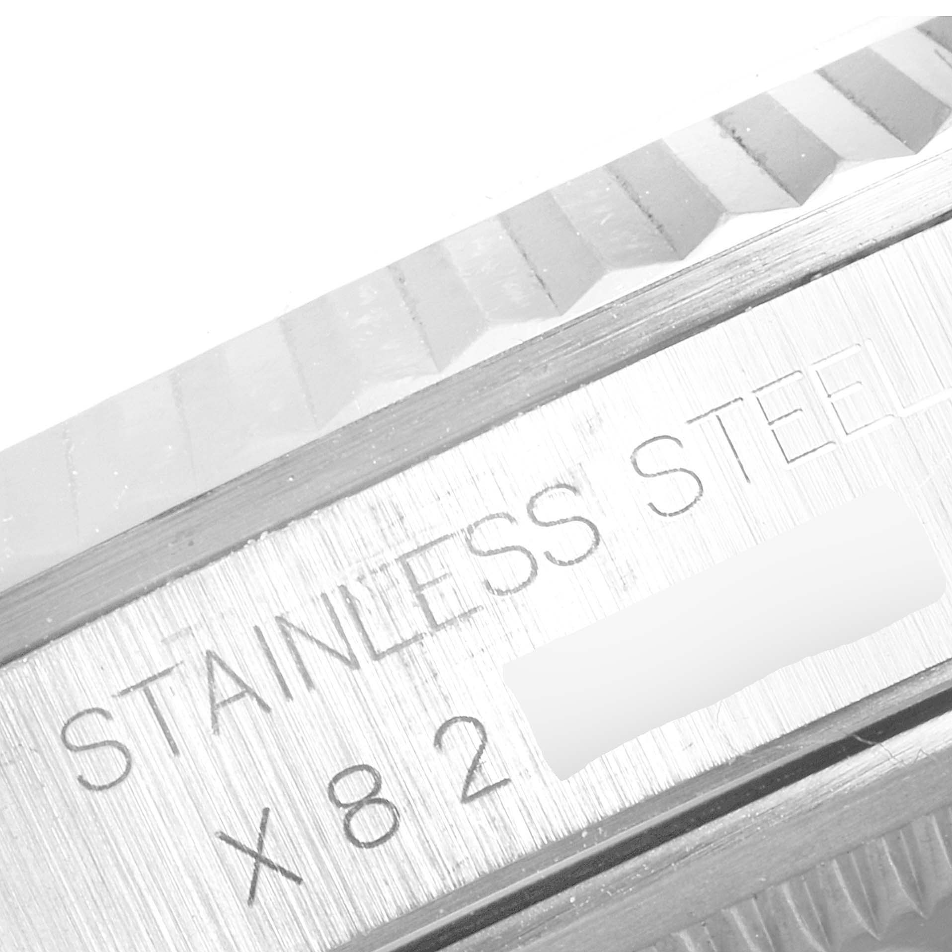 This close-up shows the fluted bezel and part of the case with "STAINLESS STEEL" engraved on a Rolex Datejust 16234 Men's Stainless Steel Silver Dial 16234 Men's Stainless Steel Silver Dial model.