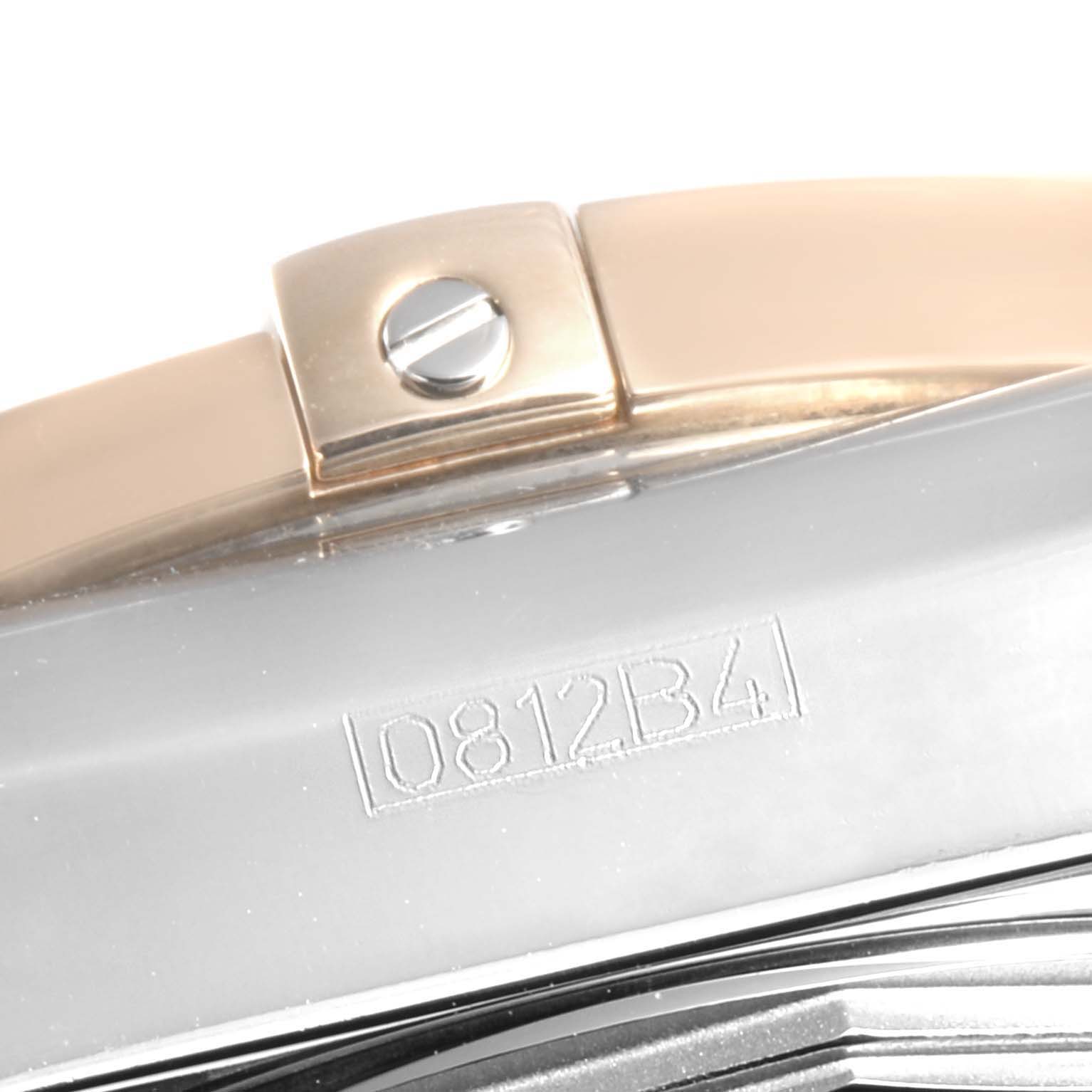 This close-up image of a Breitling Chronomat CB0140Y2/A743-378C Men's Steel and Gold (two tone) Silver Dial CB0140Y2/A743-378C Men's Steel and Gold (two tone) Silver Dial watch shows part of the metal strap, a screw, and the engraved serial number.